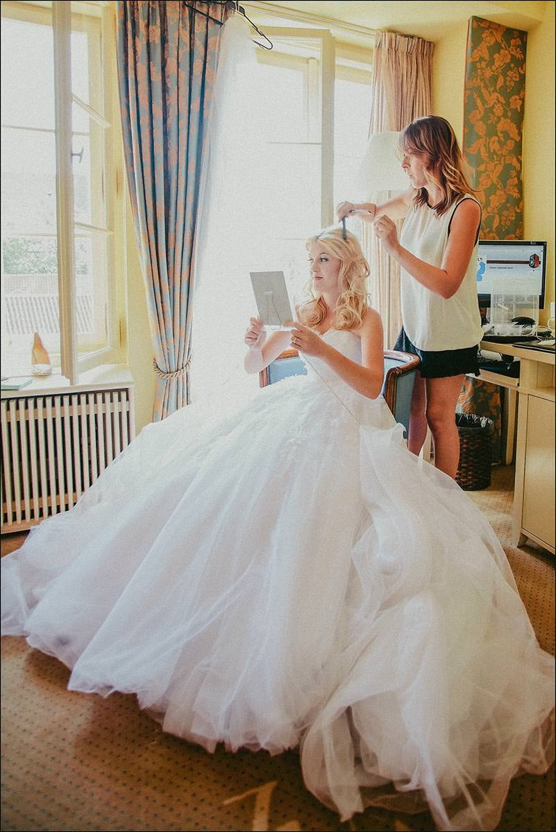 Bride Michelle is inspecting her hair and makeup in the mirror before her Vrtba Garden wedding