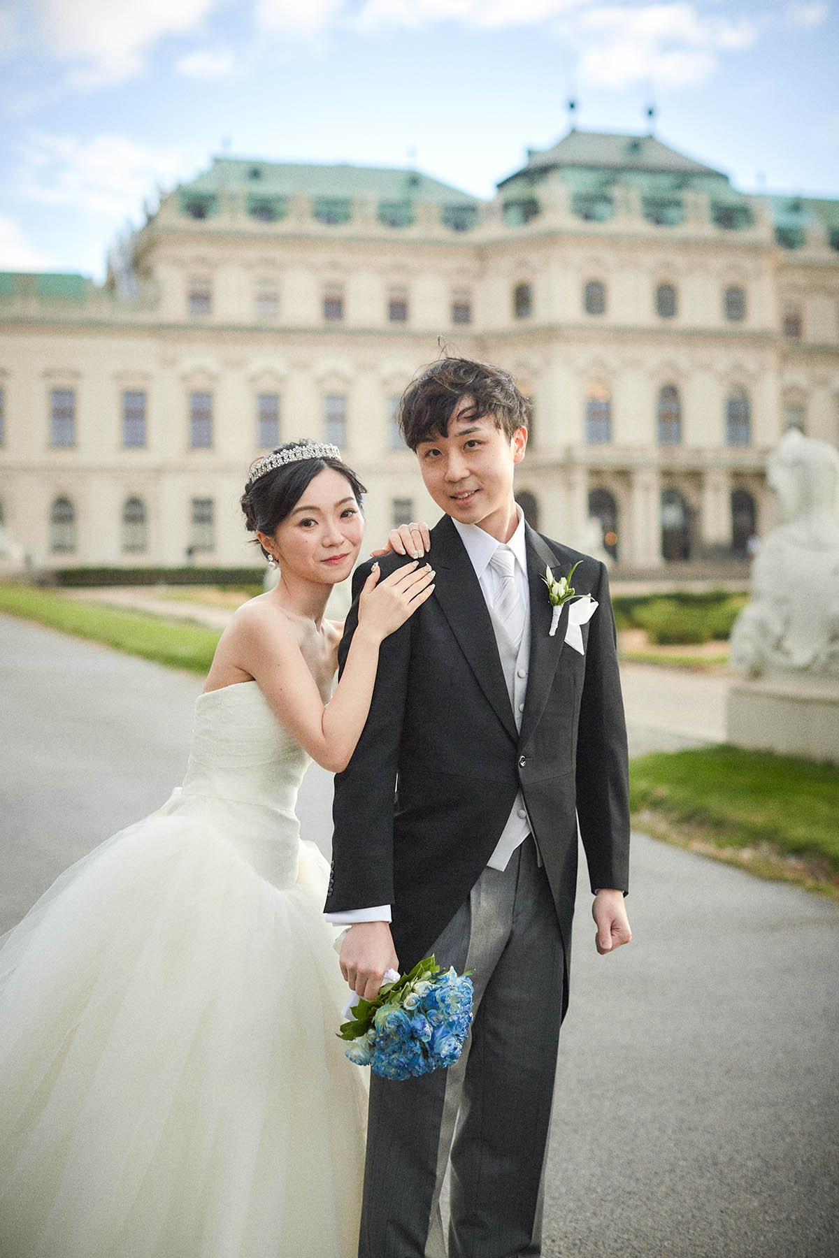 Bride embracing groom from behind in Belvedere gardens portrait.
