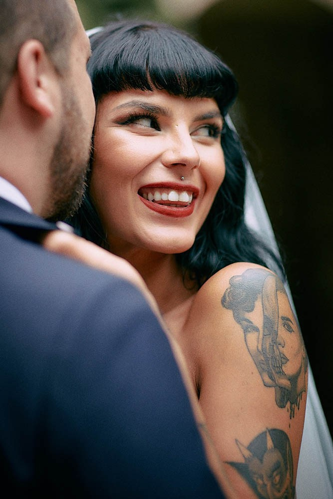 Newlyweds embracing in lush romantic Grebovka Park artificial grotto.
