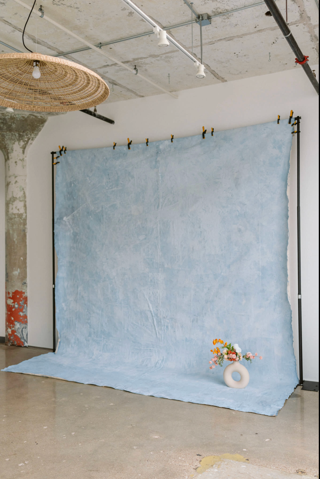 Minimalist photography studio with fresh floral arrangements and soft backdrop