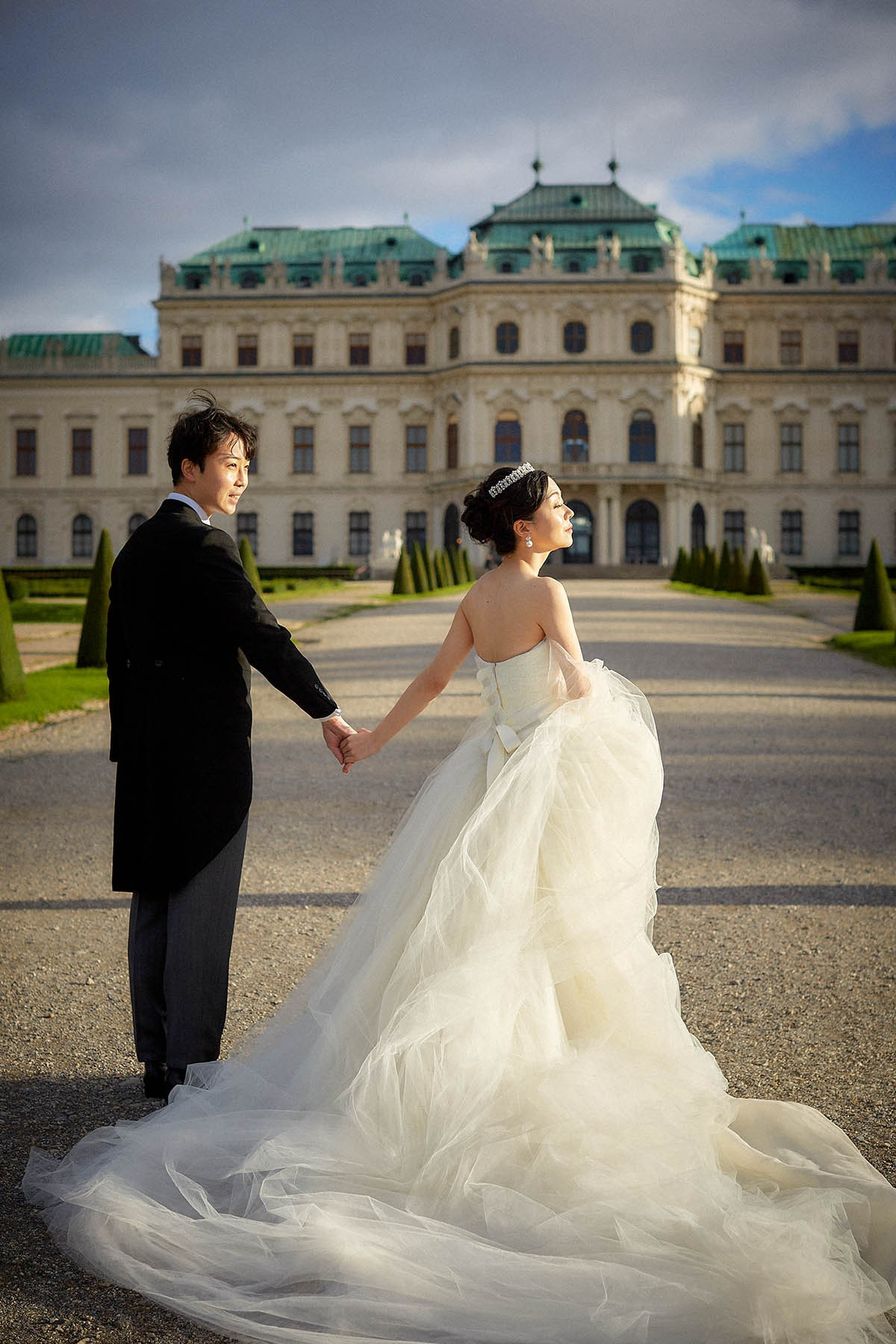 Bride facing sunlight while walking to Belvedere Palace.