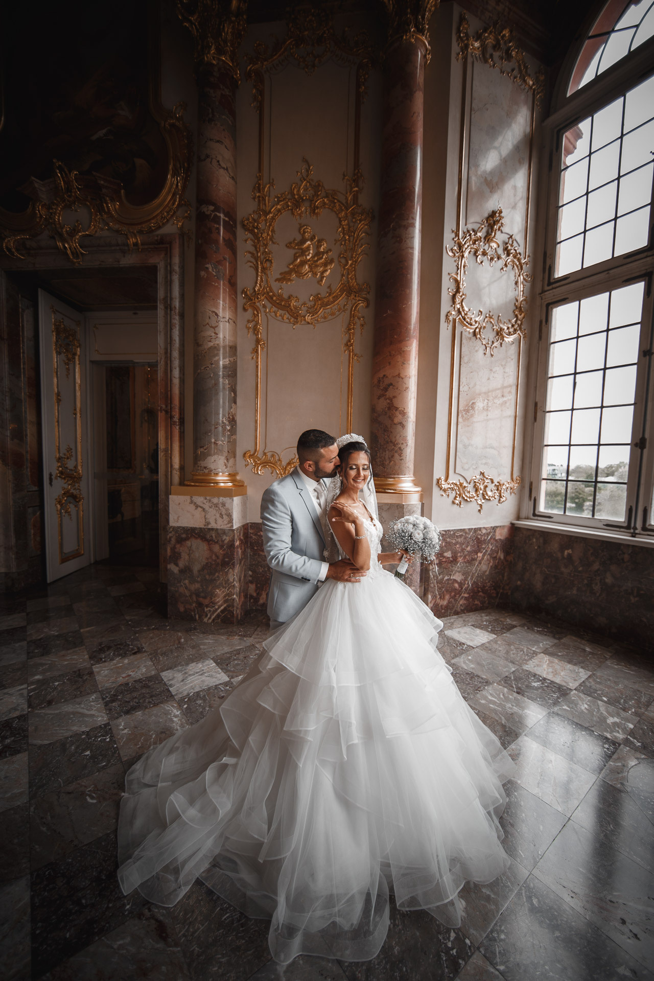 Romantisches Kussfoto des Paares vor den antiken Schlossfenstern