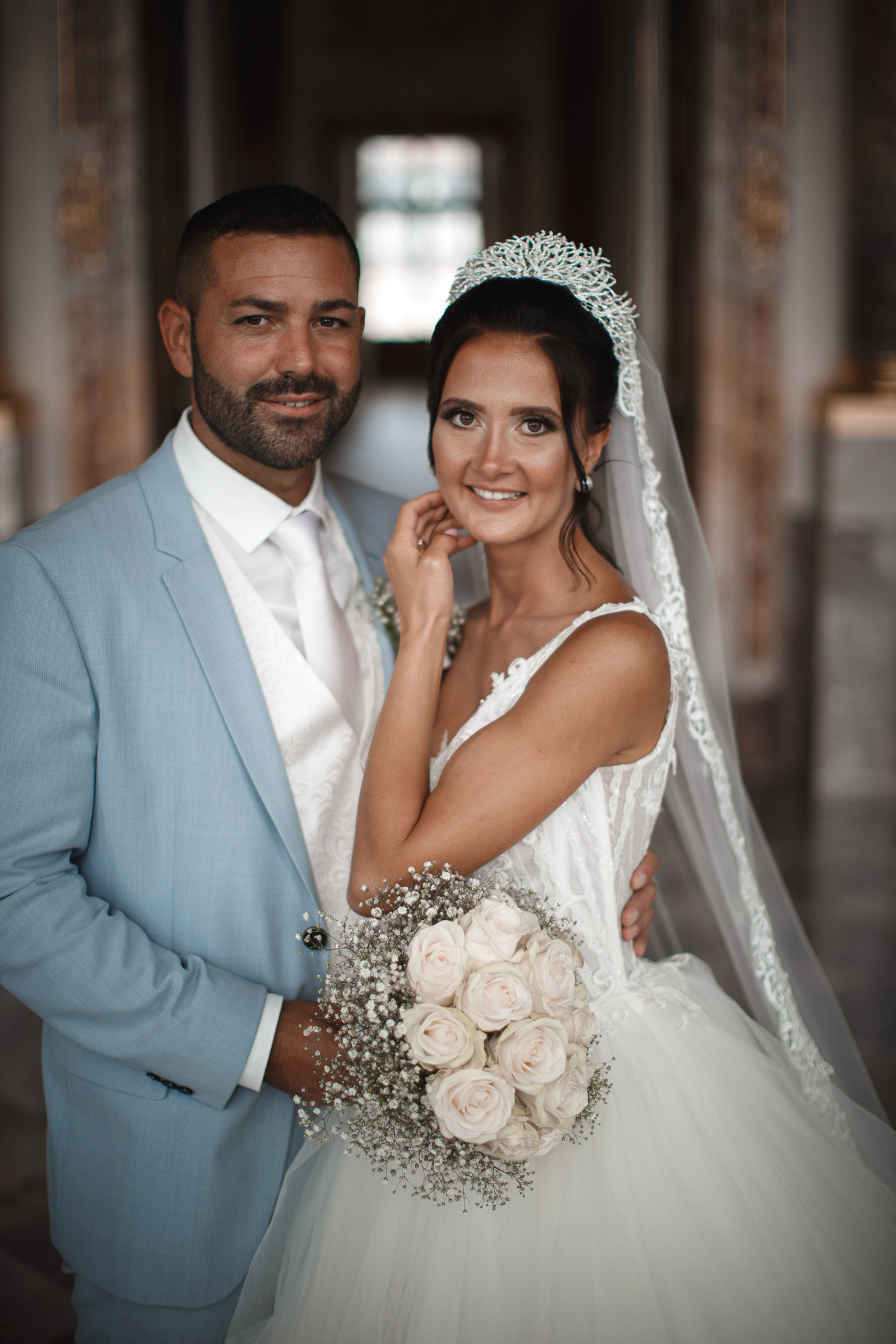 Die Braut strahlt in ihrem traumhaften Hochzeitskleid neben dem Bräutigam im Schloss Bruchsal