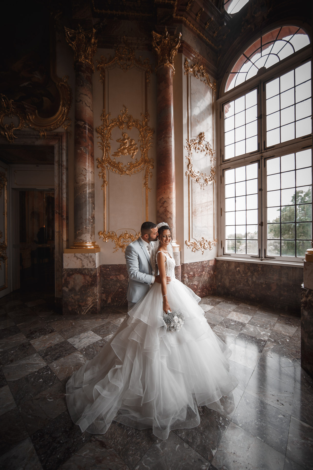 Romantisches Kussfoto des Paares vor den antiken Schlossfenstern