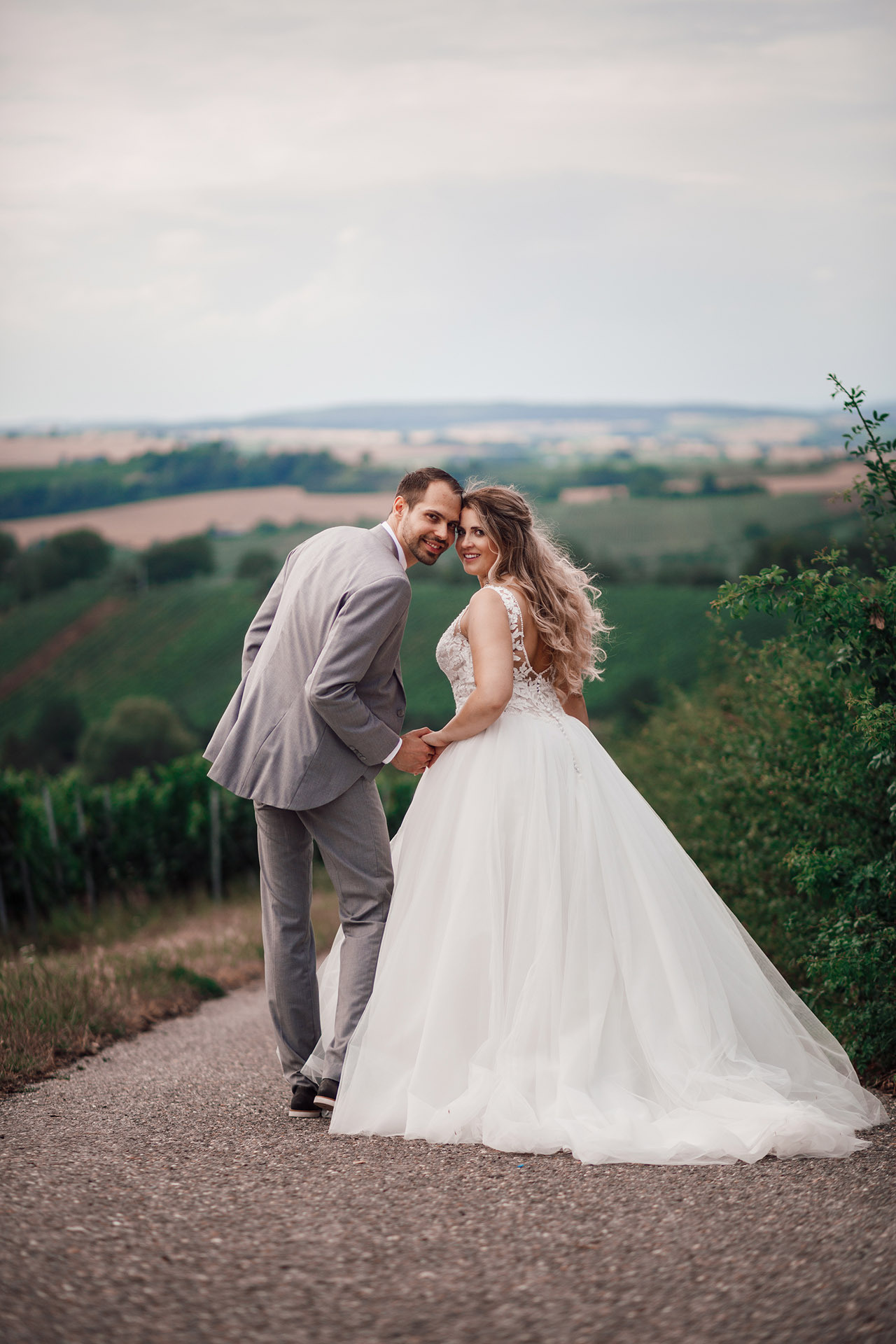 Braut und Bräutigam küssen sich mit Blick auf die Weinberge – romantische Hochzeitsfotografie in Karlsruhe