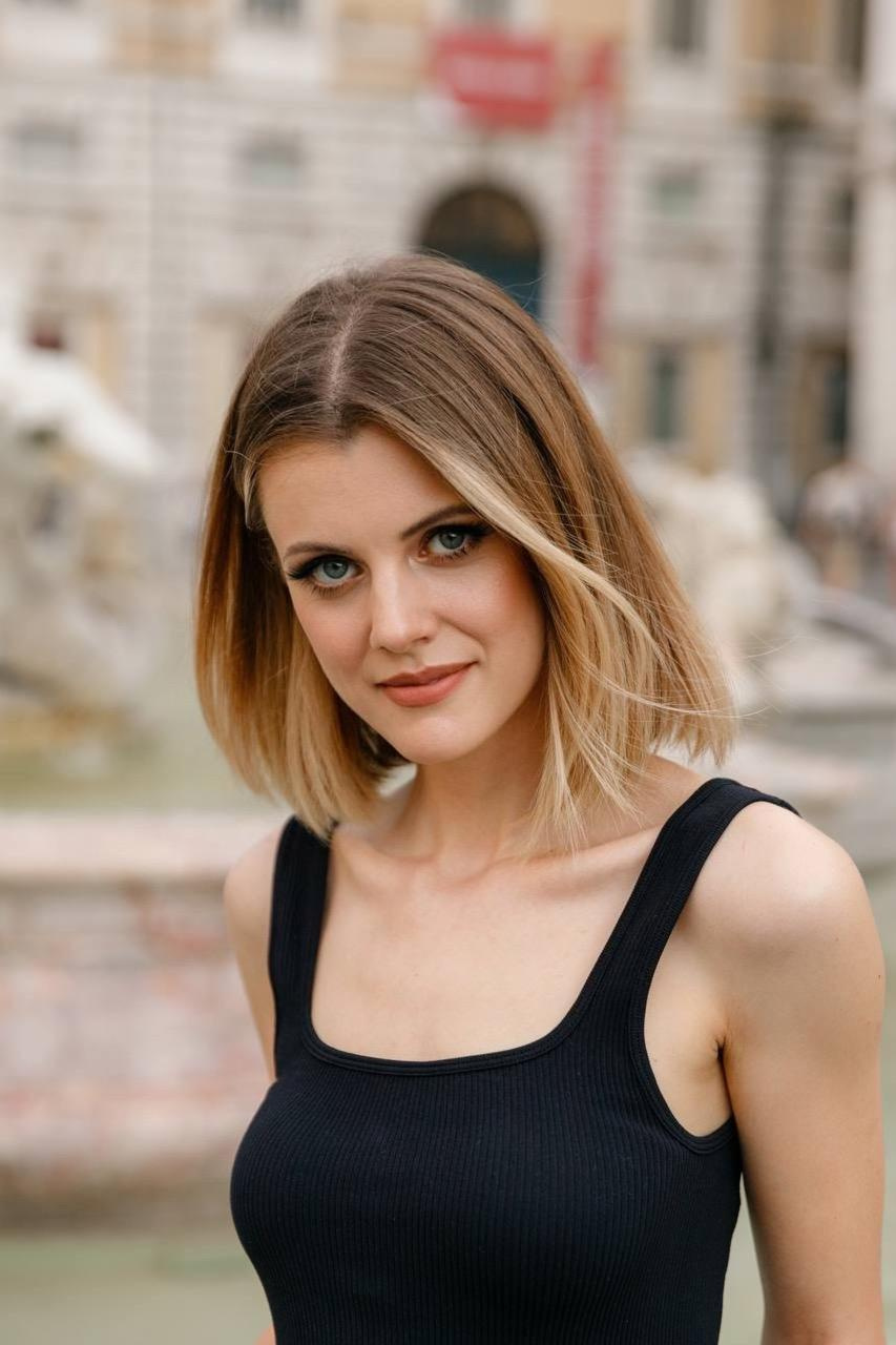 a girl in a black top and jeans posing in piazza navona in rome.