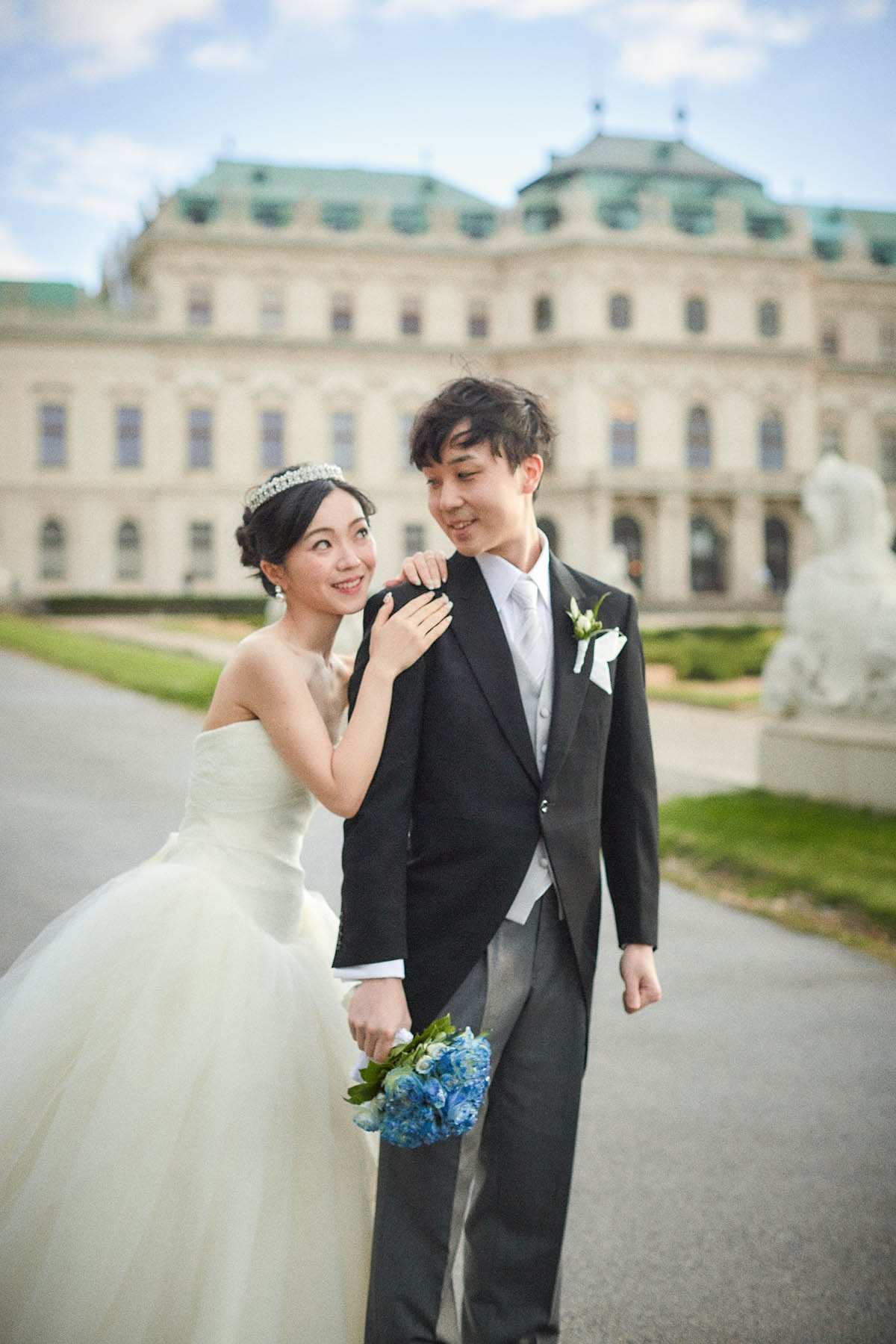 Bride embracing groom from behind in Belvedere gardens portrait.