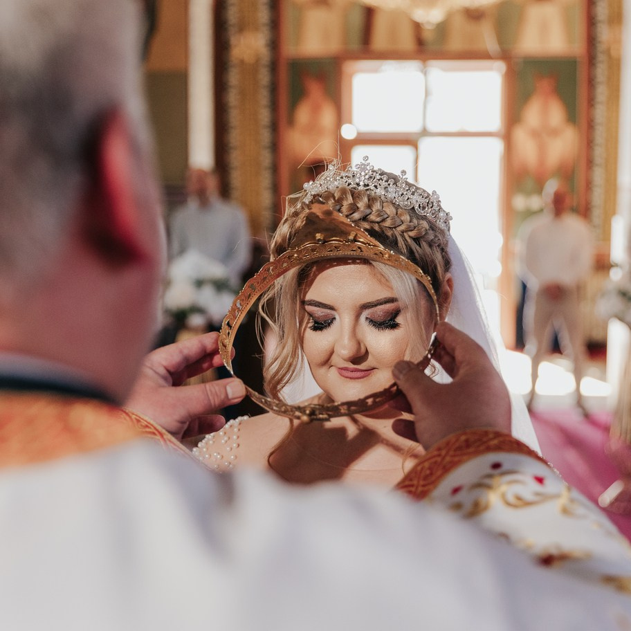 Moment de ceremonie ortodoxă cu preot și miri