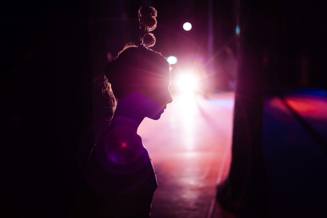 Artistic stage performance during a high-end corporate event in Milan, photographed with cinematic backlighting.