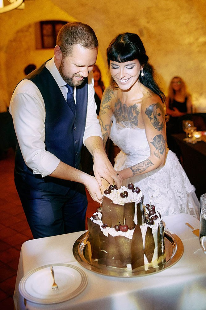 Newlyweds smiling during the traditional cake cutting brewery bar.