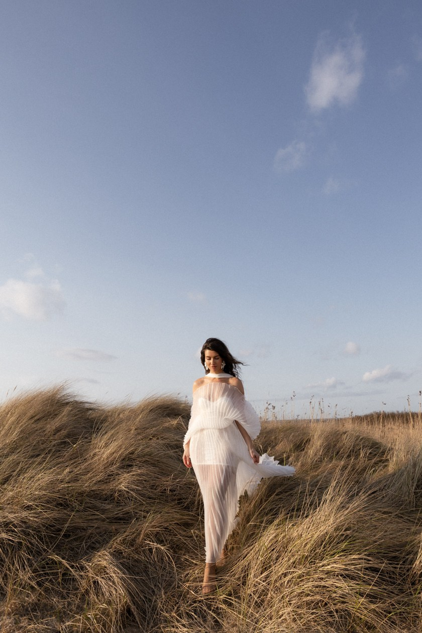 Braut im weißen Kleid auf Dünen, natürliche Hochzeitsfotografie.
