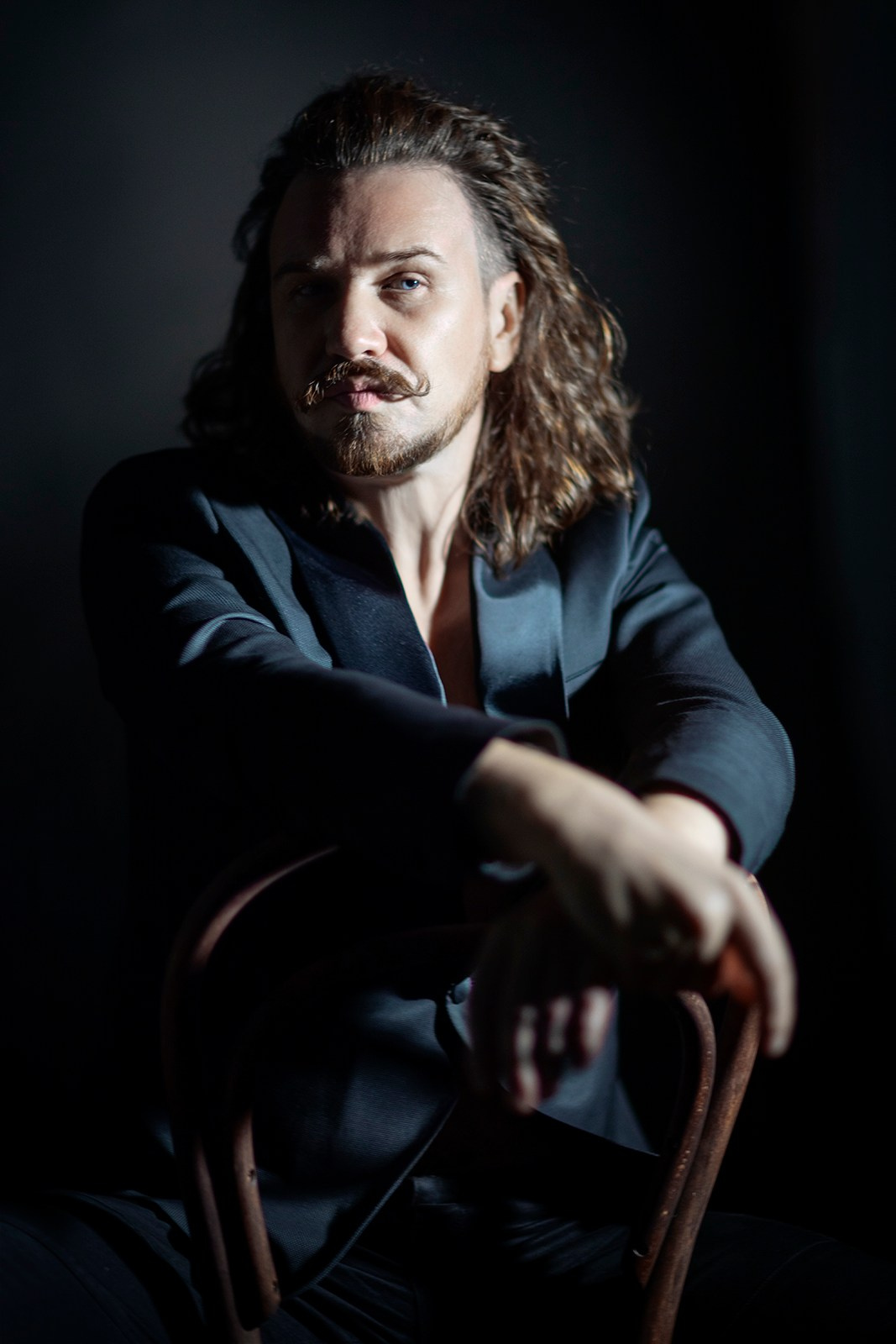 Художественный портрет мужчины в пиджаке на чёрном фоне, студийная фотосессия