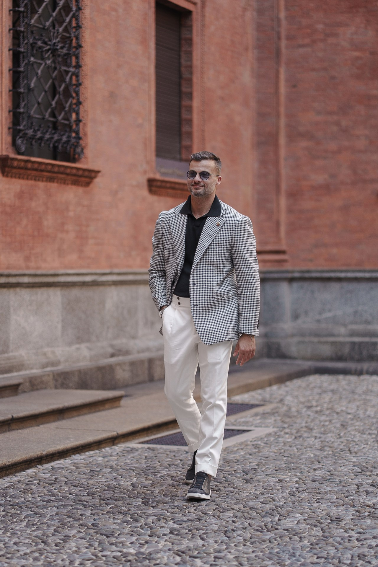 Male street portrait beside a red brick building in central Milan