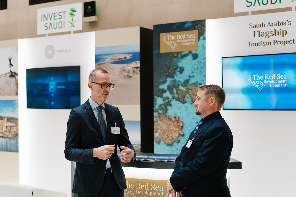 Two professionals talking at exhibition stand during business conference in Berlin
