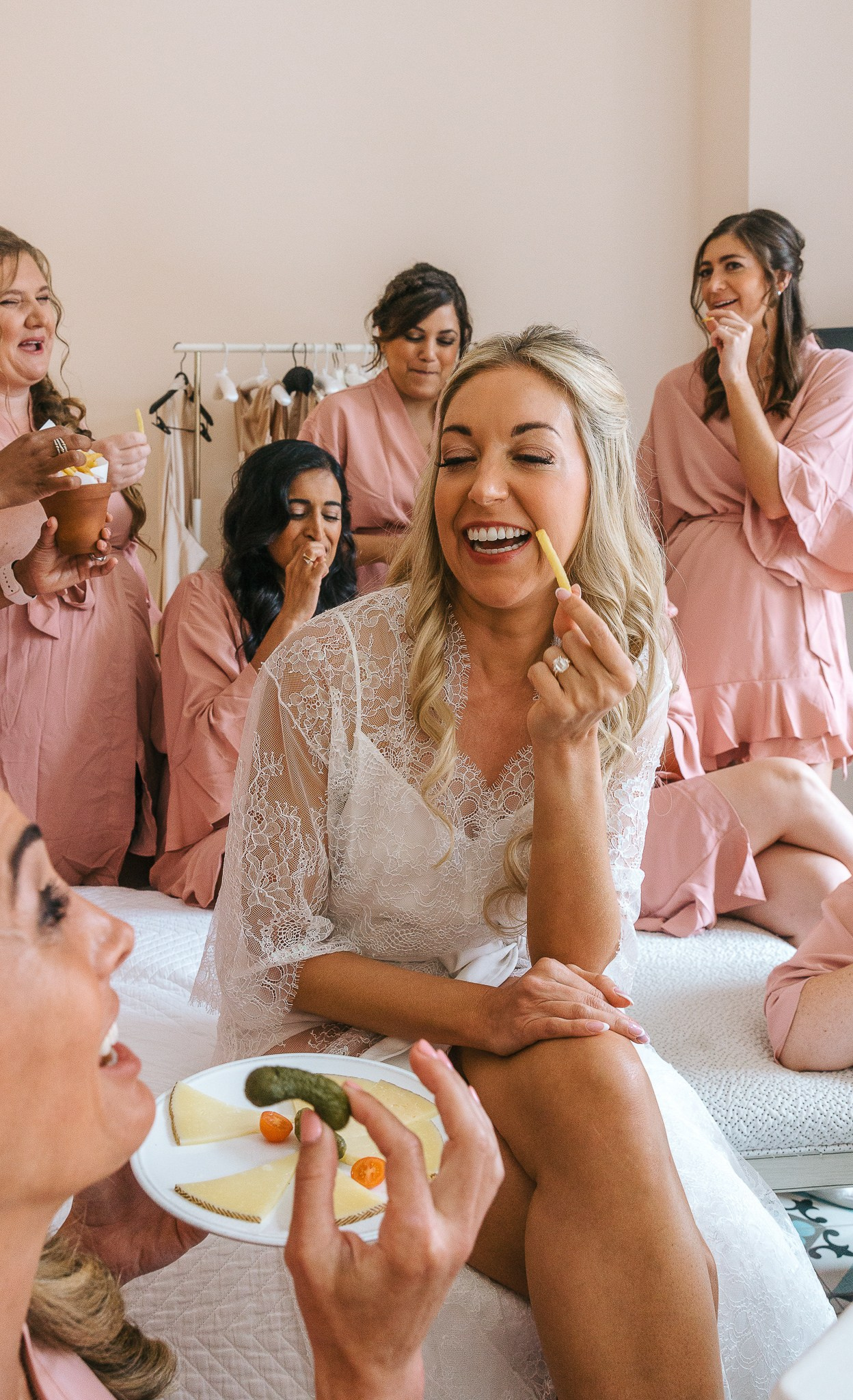 Bride laughing with her bridesmaids while getting ready for her Mallorca wedding