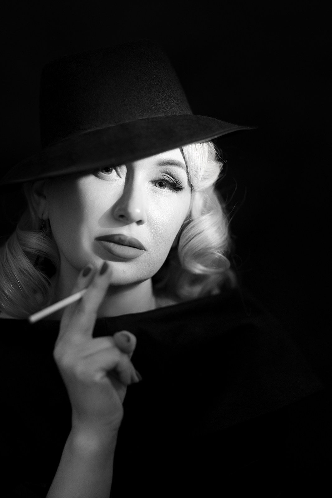 Чёрно-белый винтажный портрет женщины в шляпе с загадочным выражением