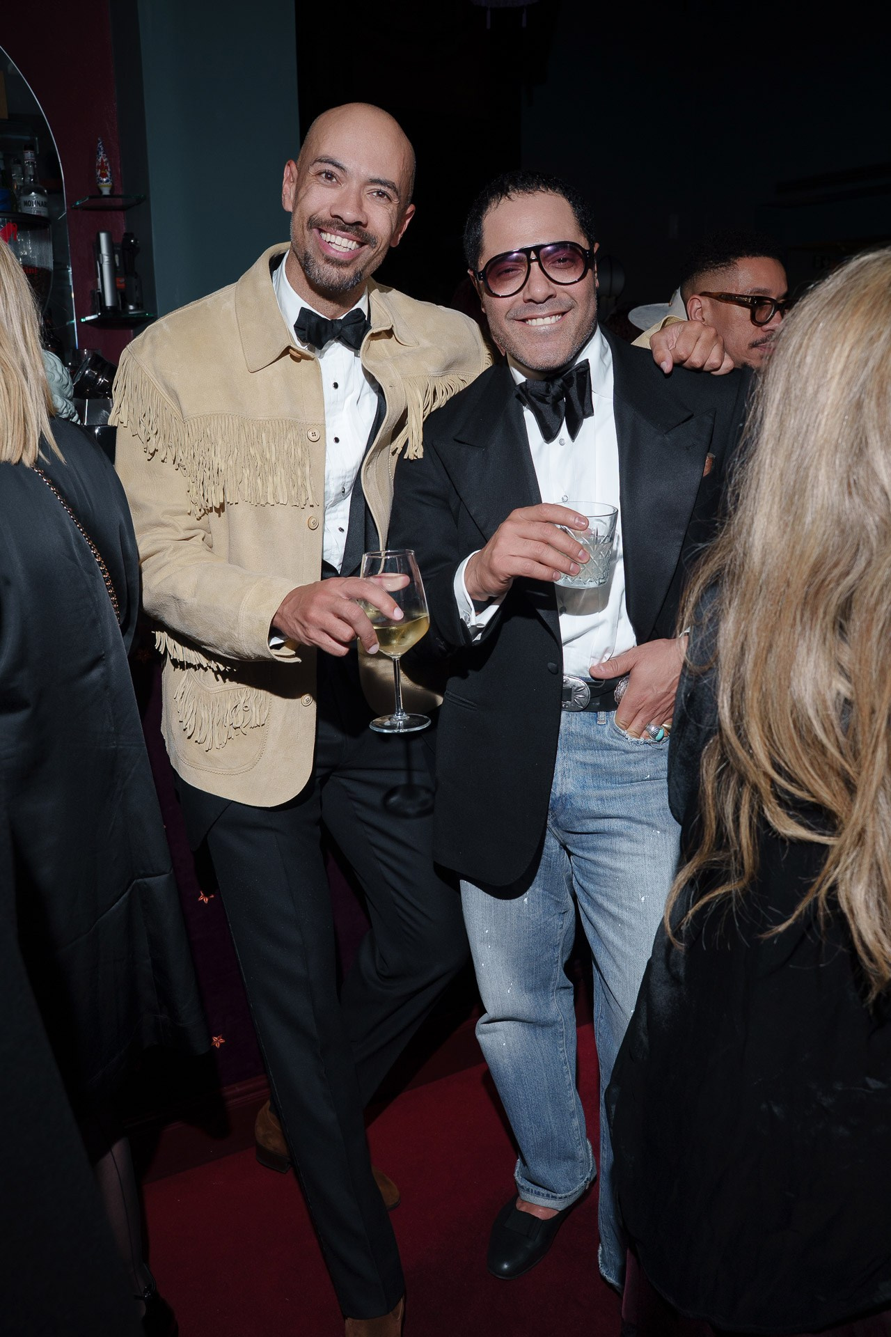 Two men in tuxedos holding drinks during private luxury cocktail event