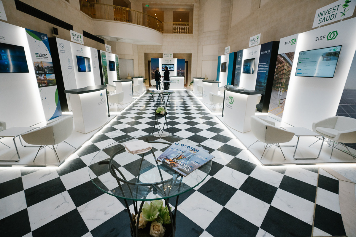 Modern exhibition space with black and white floor and information stands at a business conference in Berlin