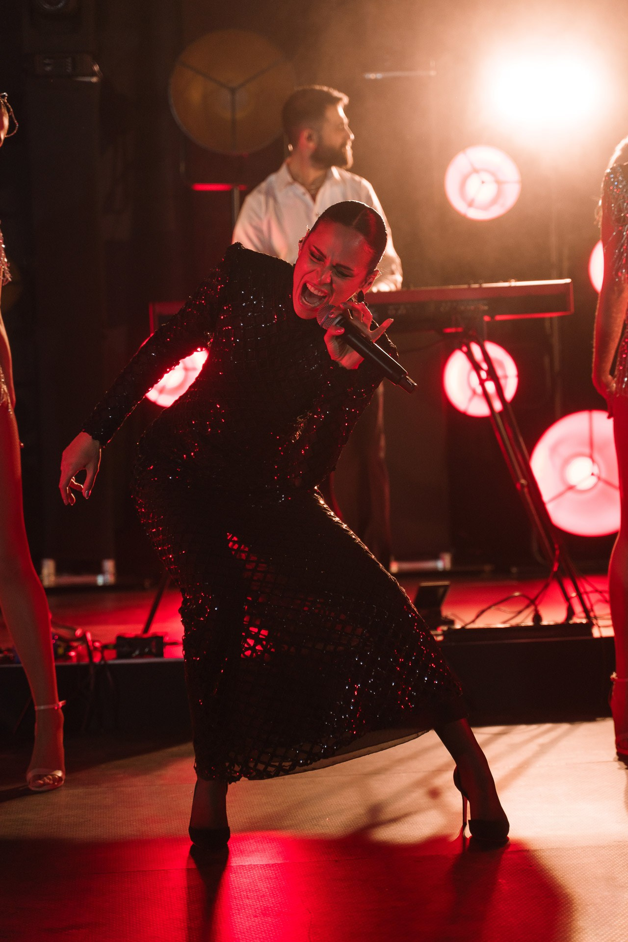 Professional event photography of a live performance with dramatic stage lighting and atmospheric effects.