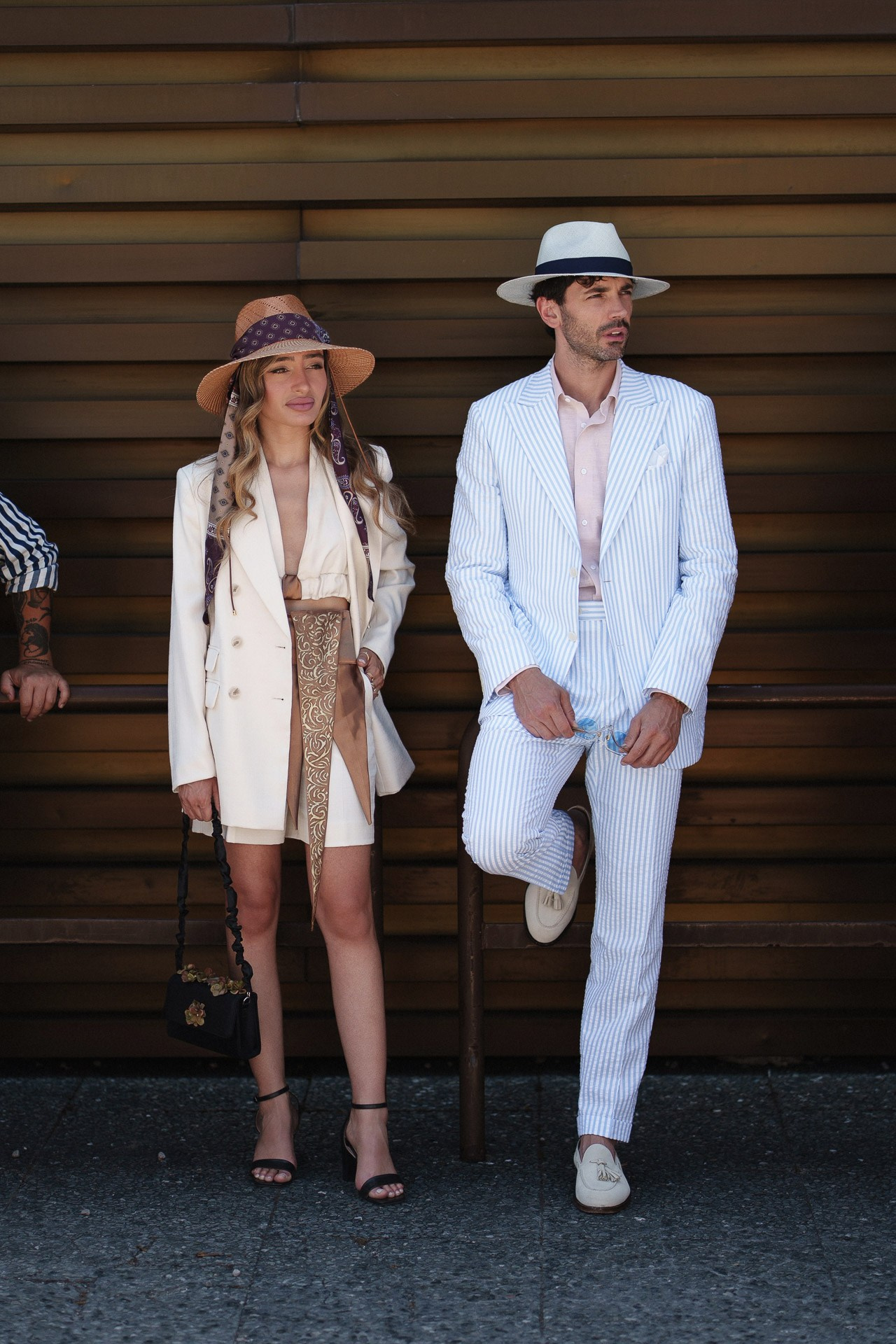Coppia street style da Pitti Uomo 110, ospiti in outfit estivi chiari e cappelli fuori dalla Fortezza da Basso