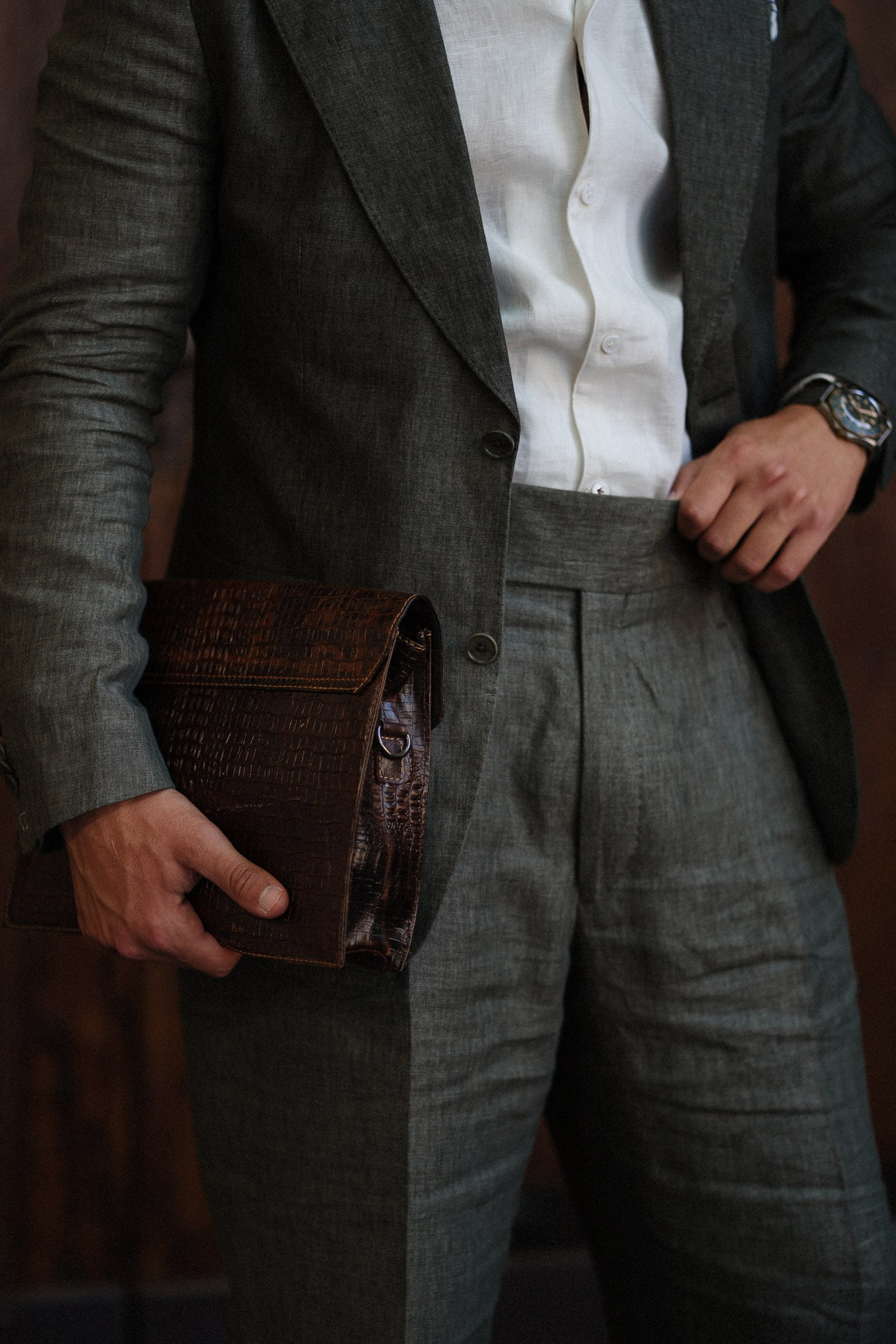 Dettaglio da Pitti Uomo 110, completo grigio, camicia bianca, orologio e borsa in pelle marrone