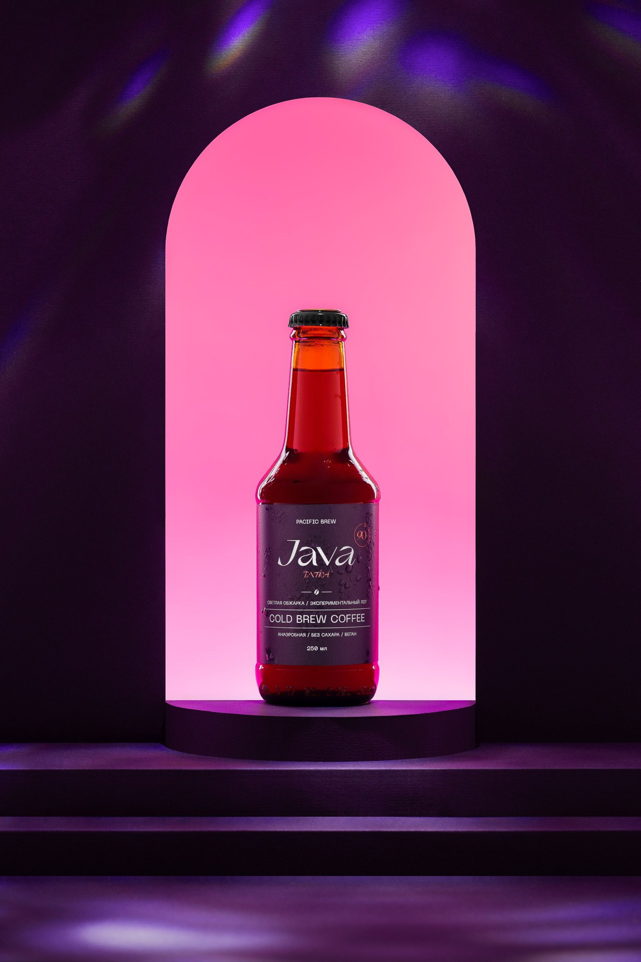 Product photography of bottled drink with pink light and clean background