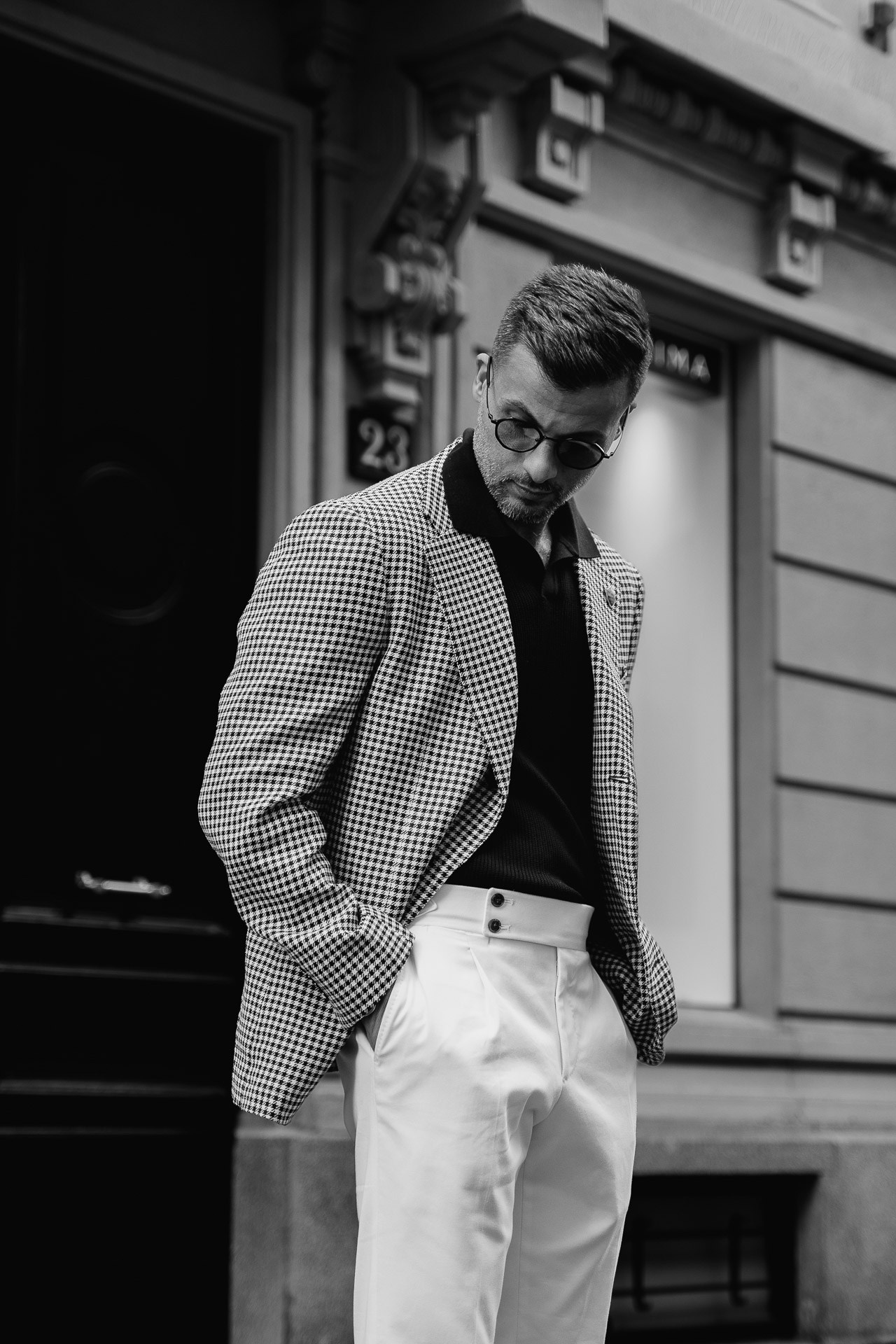 Black and white fashion portrait of a man in a checked blazer in Milan