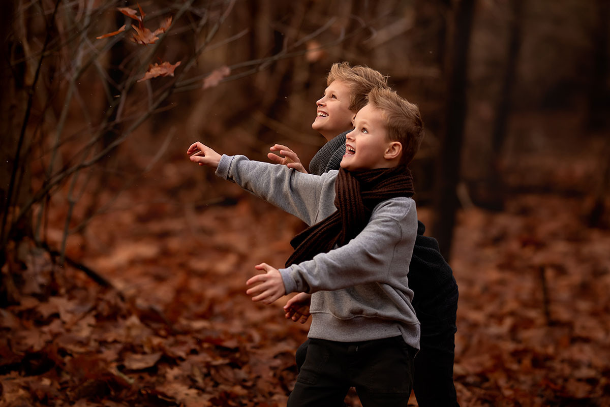 Najaar fotoshoot met twee jongens in beweging en de bladeren