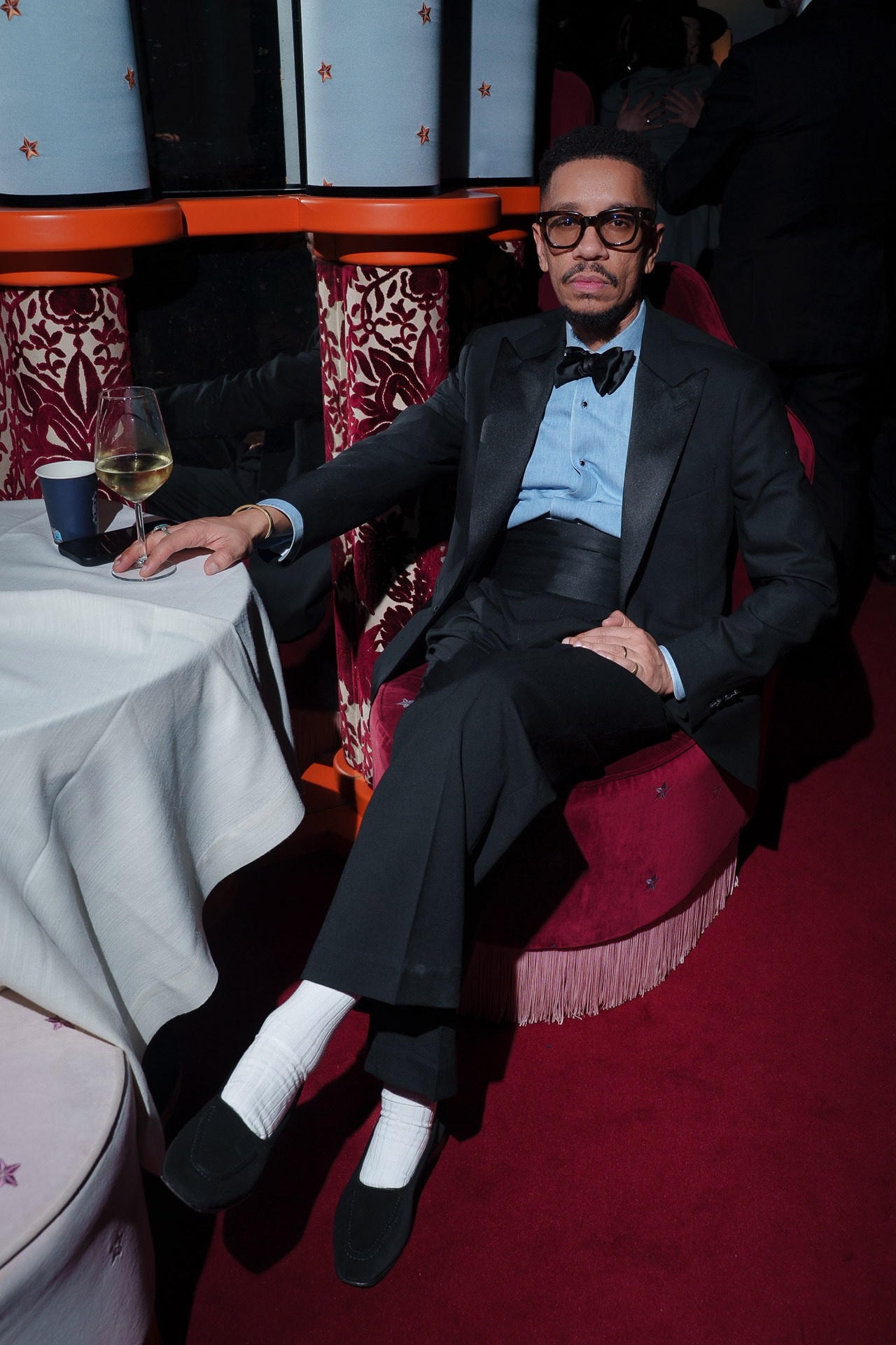 Man in tuxedo sitting at table during formal evening event