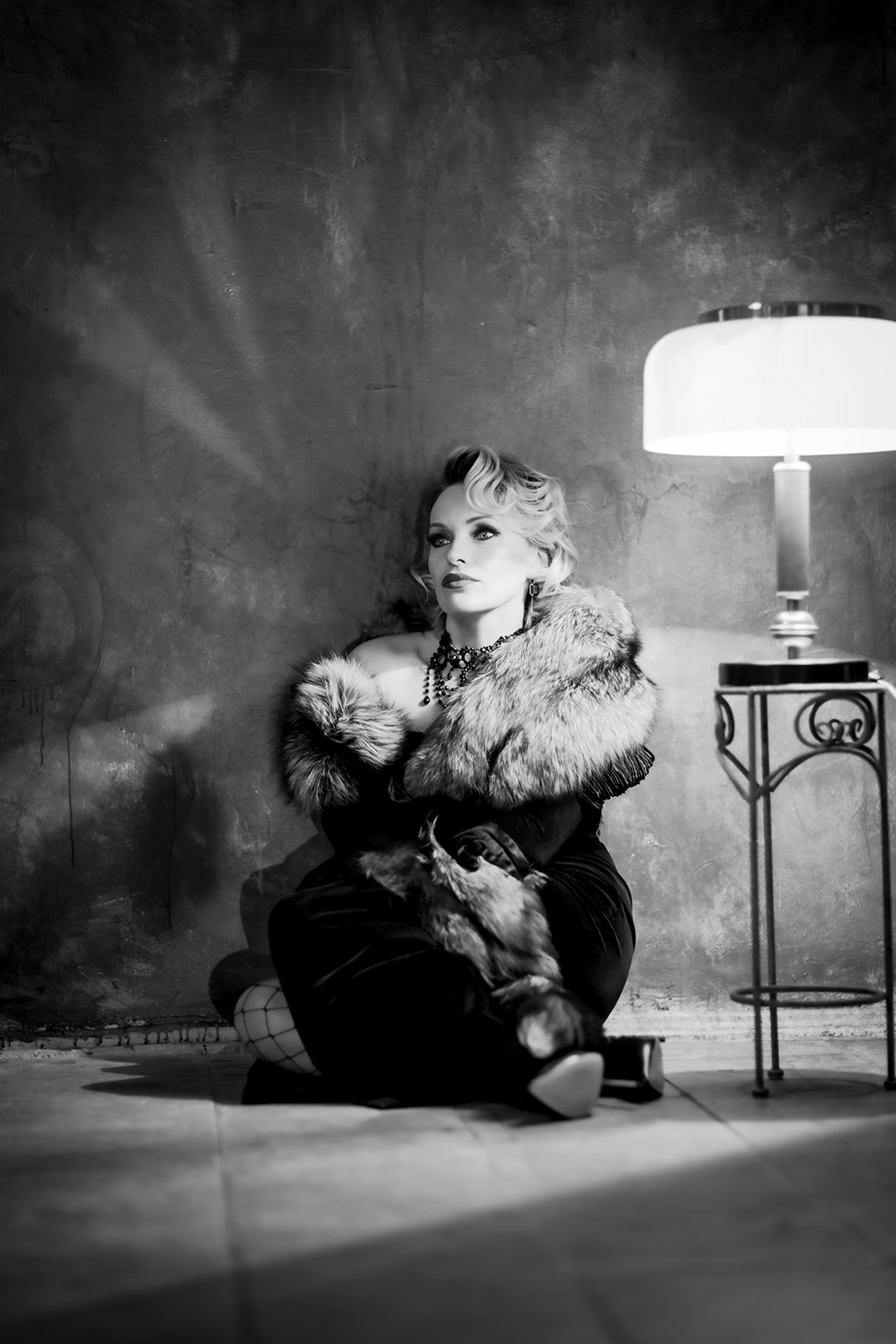 Стилизованный чёрно-белый арт-портрет женщины в мехах в винтажной студии