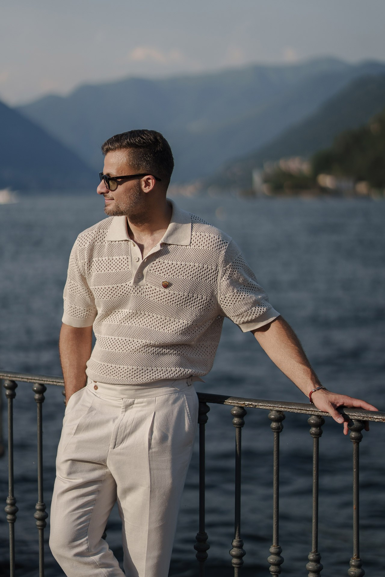 Jamal posing by the waterfront railing with Lake Como behind him