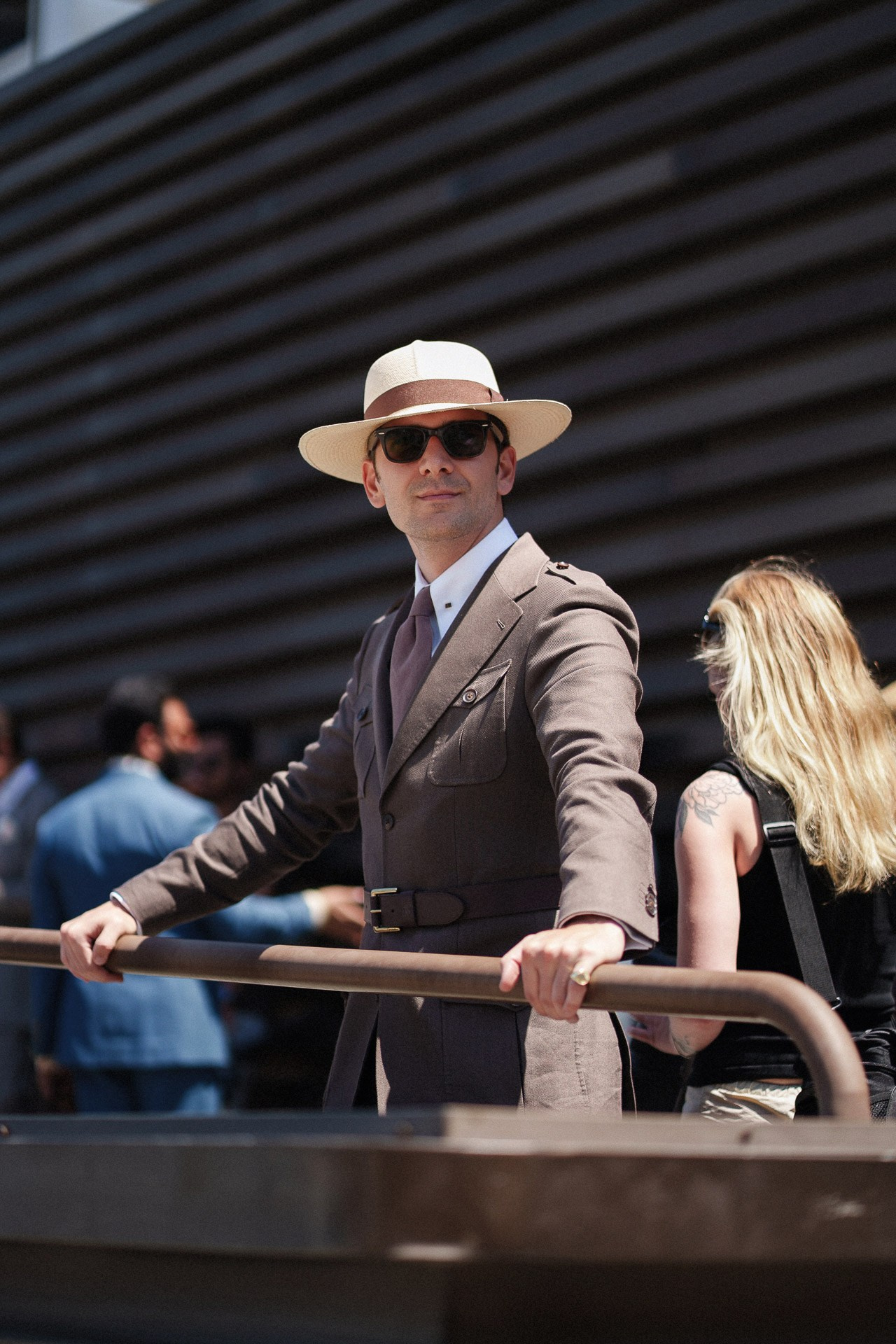 Ospite di Pitti Uomo 110 in completo estivo marrone e cappello Panama fotografato fuori dalla Fortezza da Basso