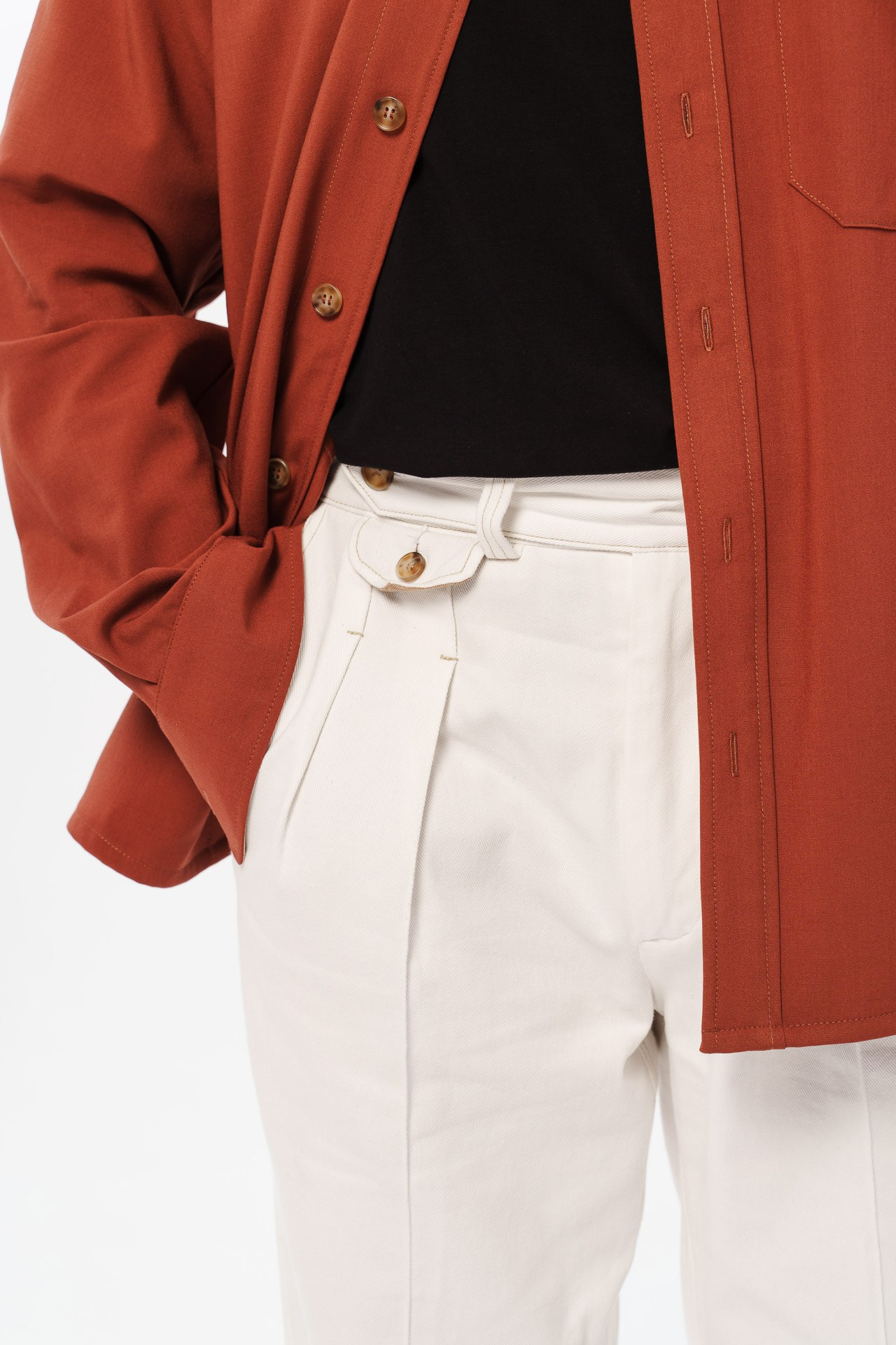 Minimal studio fashion detail shot highlighting premium fabrics and tailoring