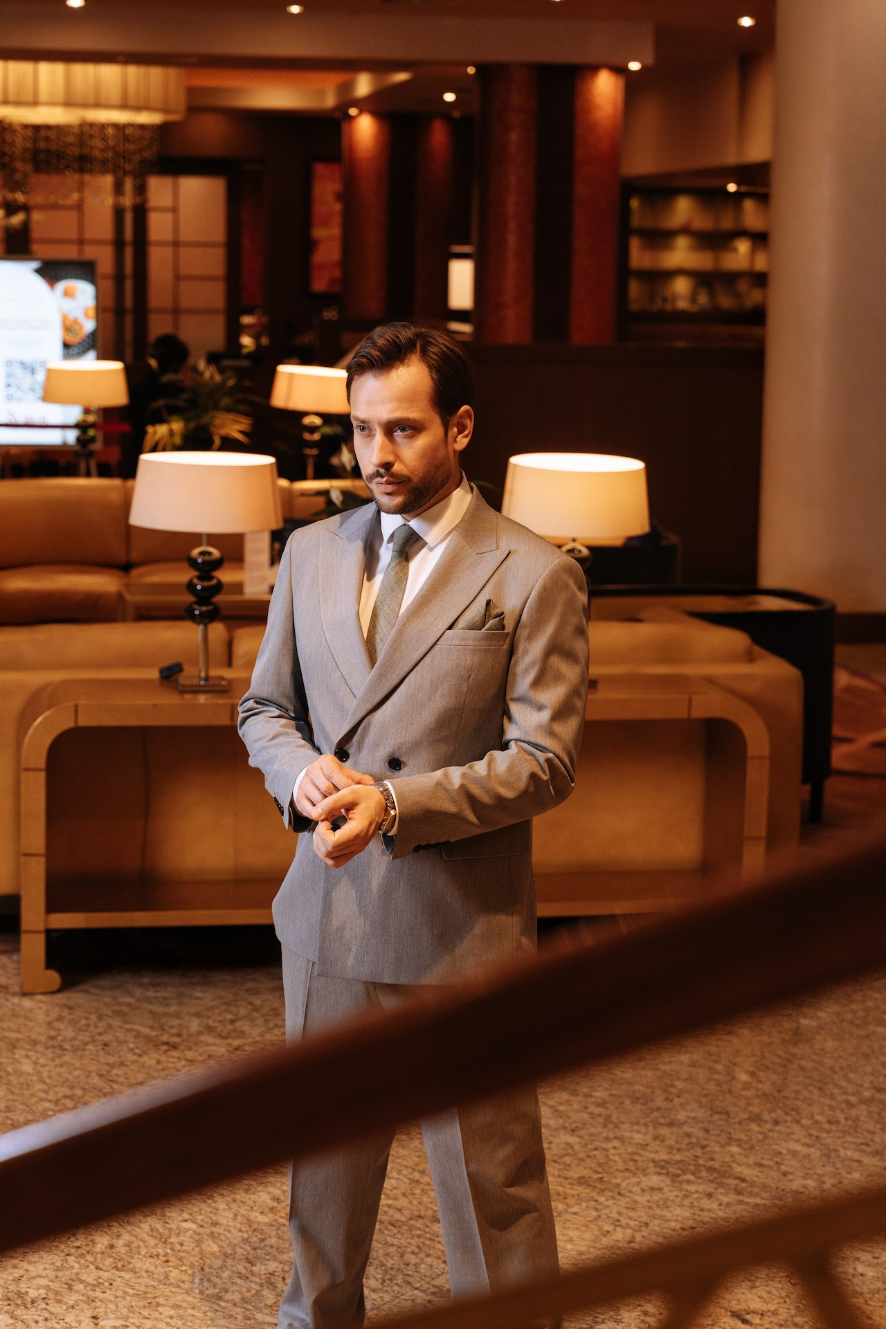 Деловой мужчина в пиджаке стоит в холле бизнес-отеля