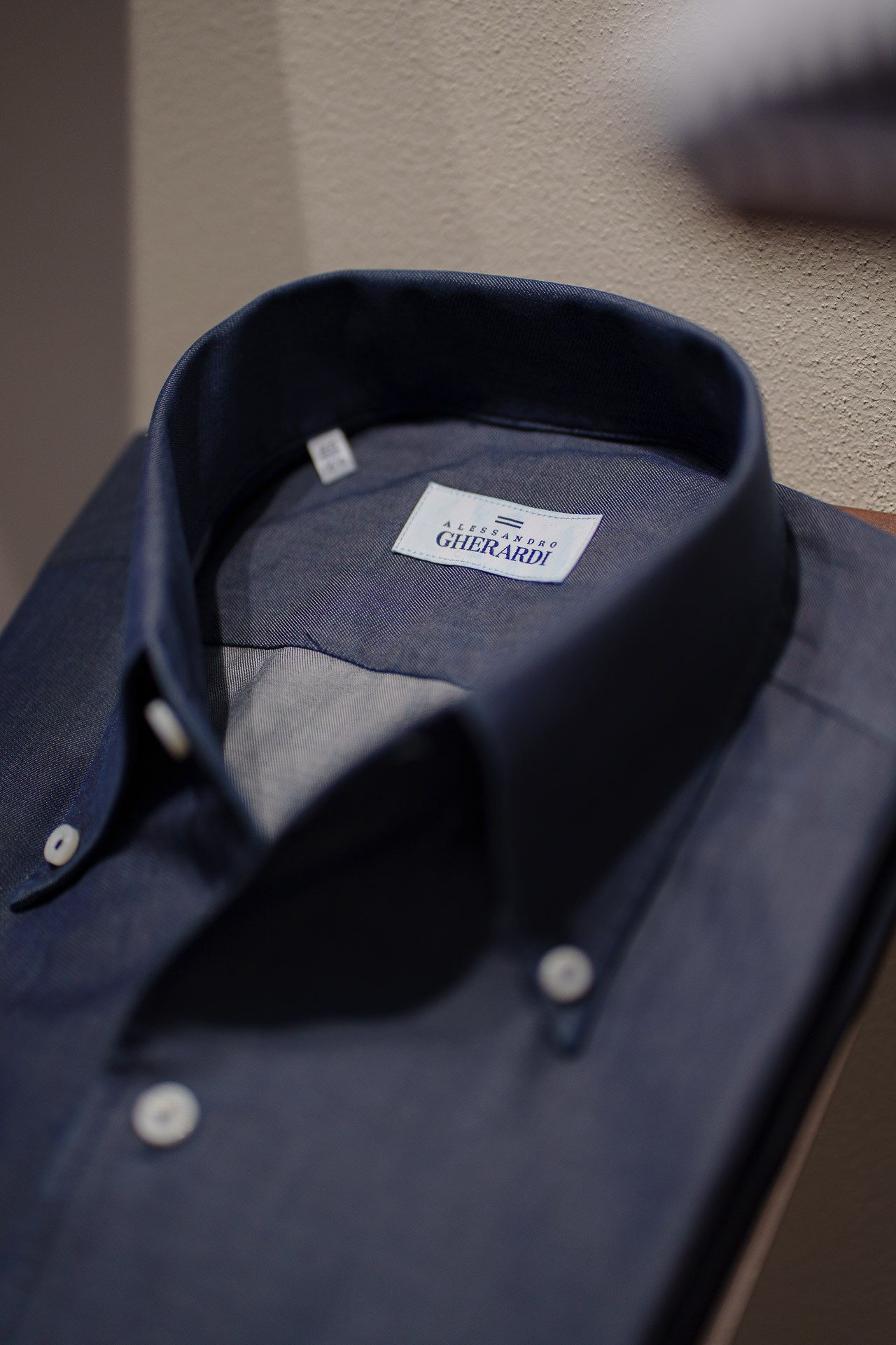 Close-up of a navy blue button-down shirt featuring the "Alessandro Gherardi" designer label