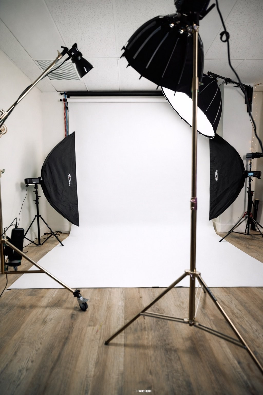 Set con fondo blanco infinito vacío preparado con tres luces softbox para una sesión de fotos