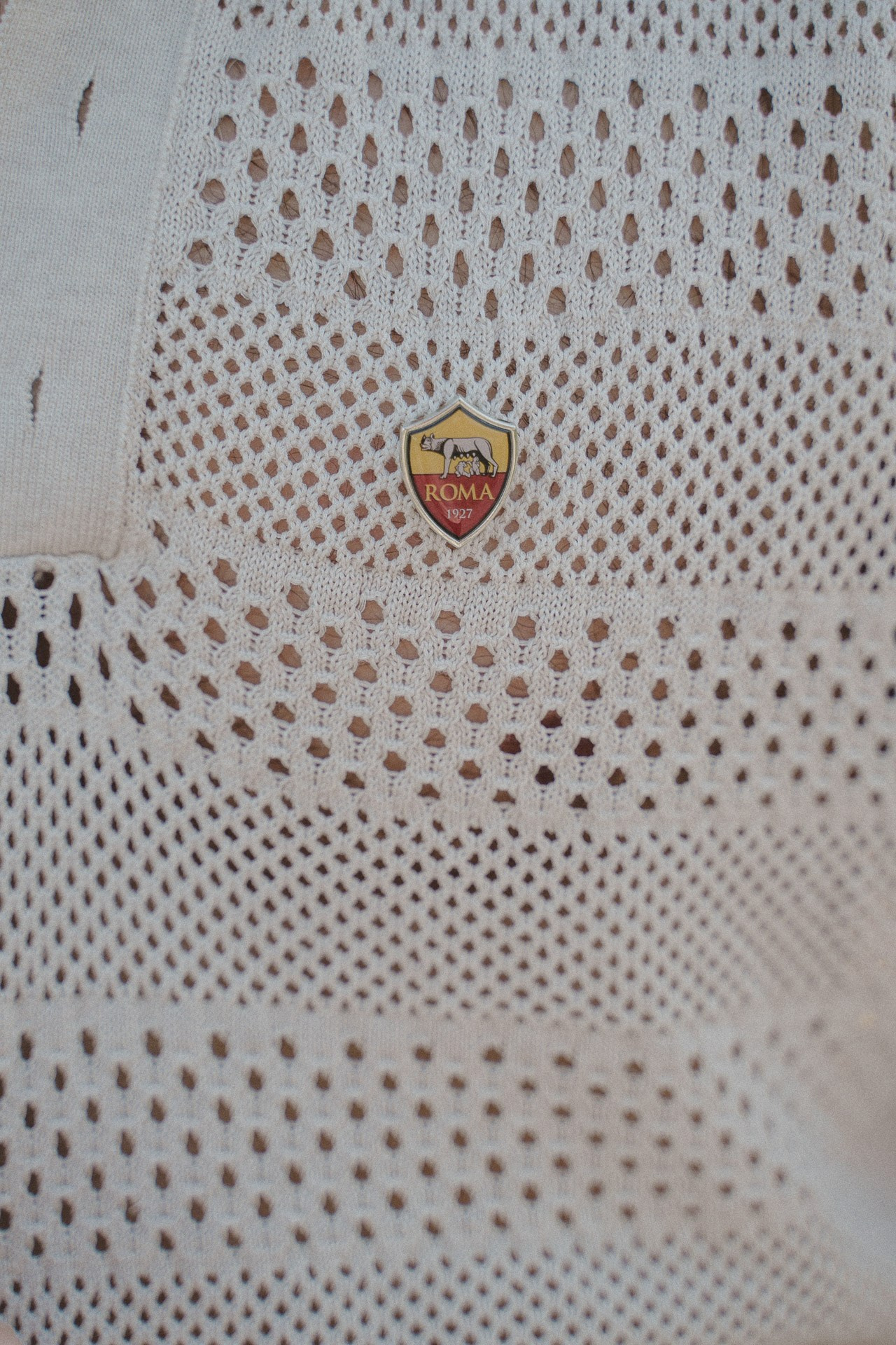 Close-up detail of a white knitted polo shirt during the Como photoshoot