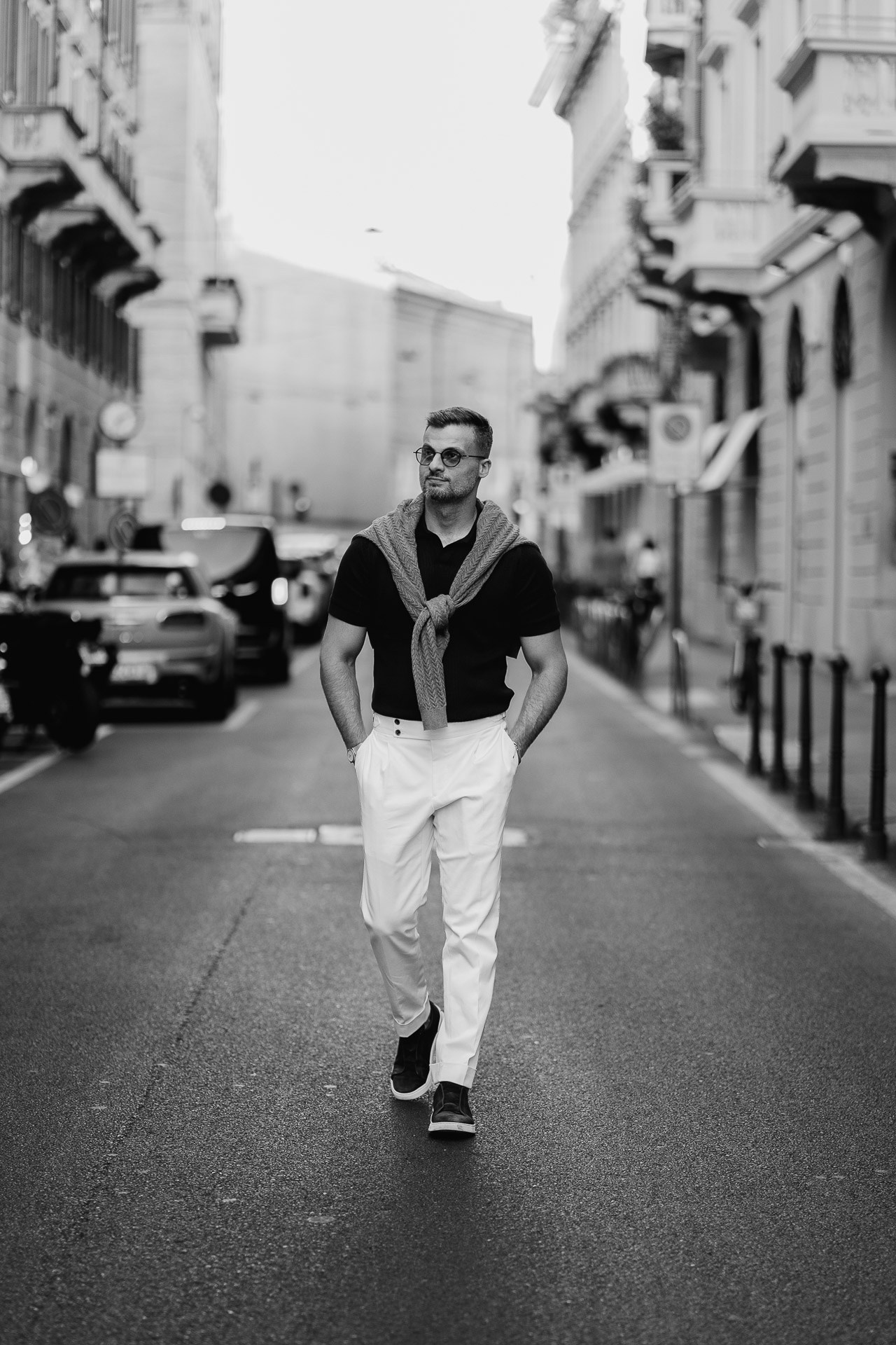 Jamal walking along a quiet street during a male photoshoot in Milan