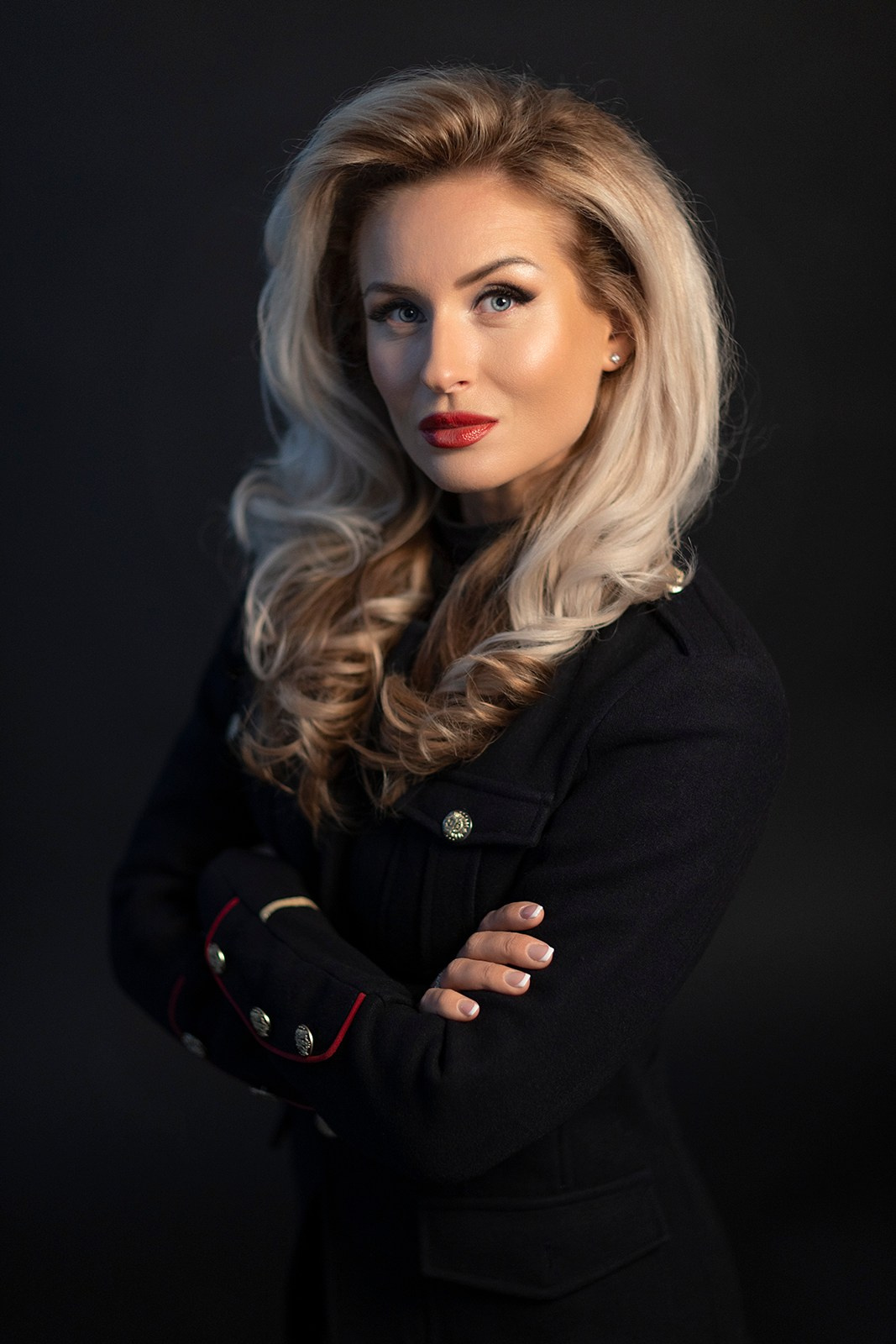 Студийный портрет женщины с волнистыми волосами и пиджаком