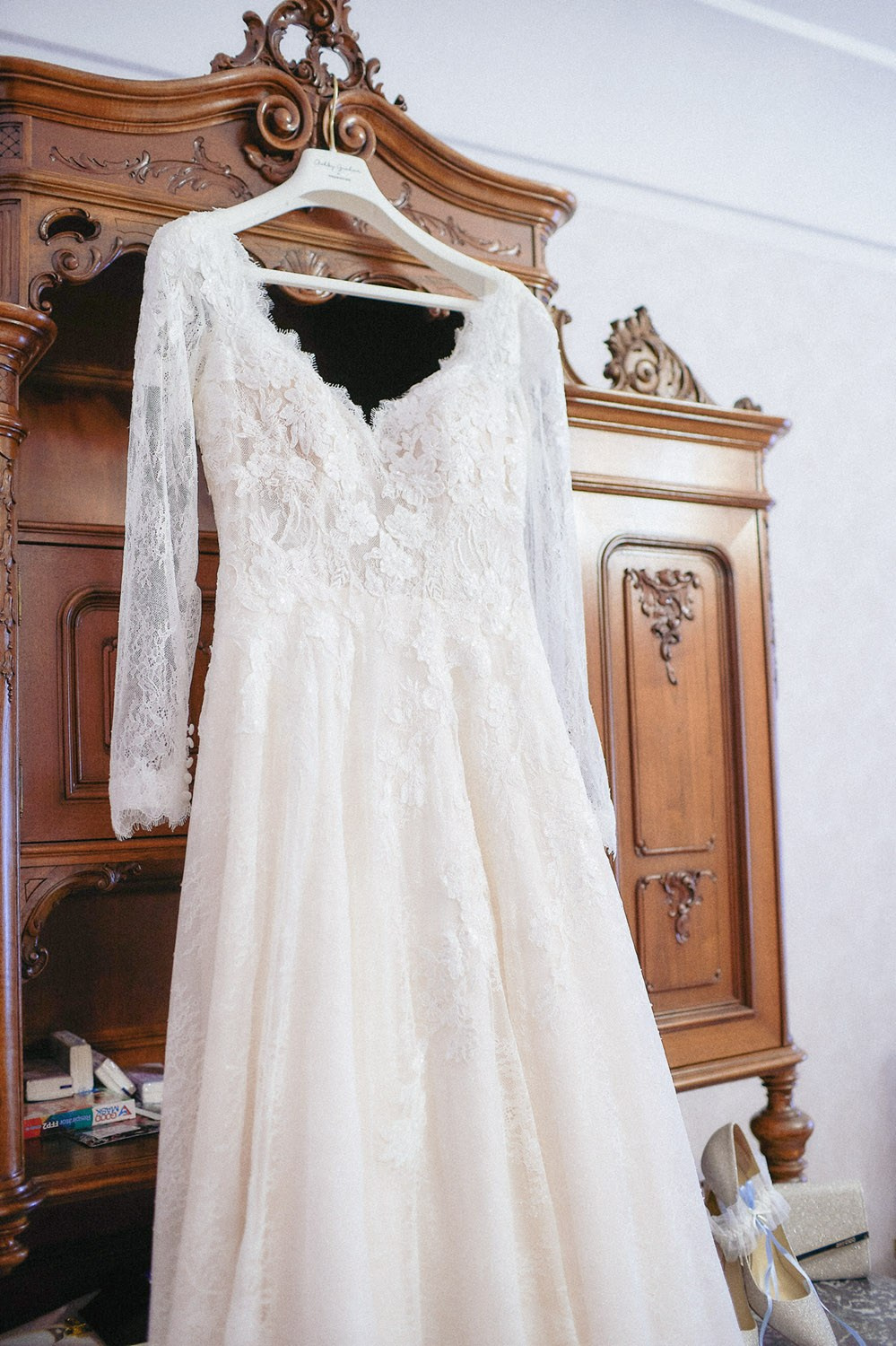 A cream-colored wedding dress hangs prominently on a antique cabinet in the bridal suite at Prague's Hotel Constance.