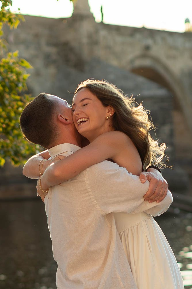 Radiant woman smiles as she is picked up by her partner in Prague.