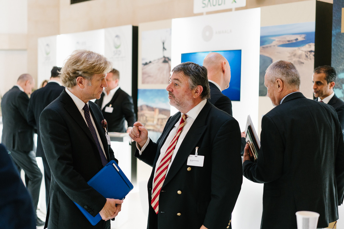 Business delegates discussing partnerships at exhibition counter