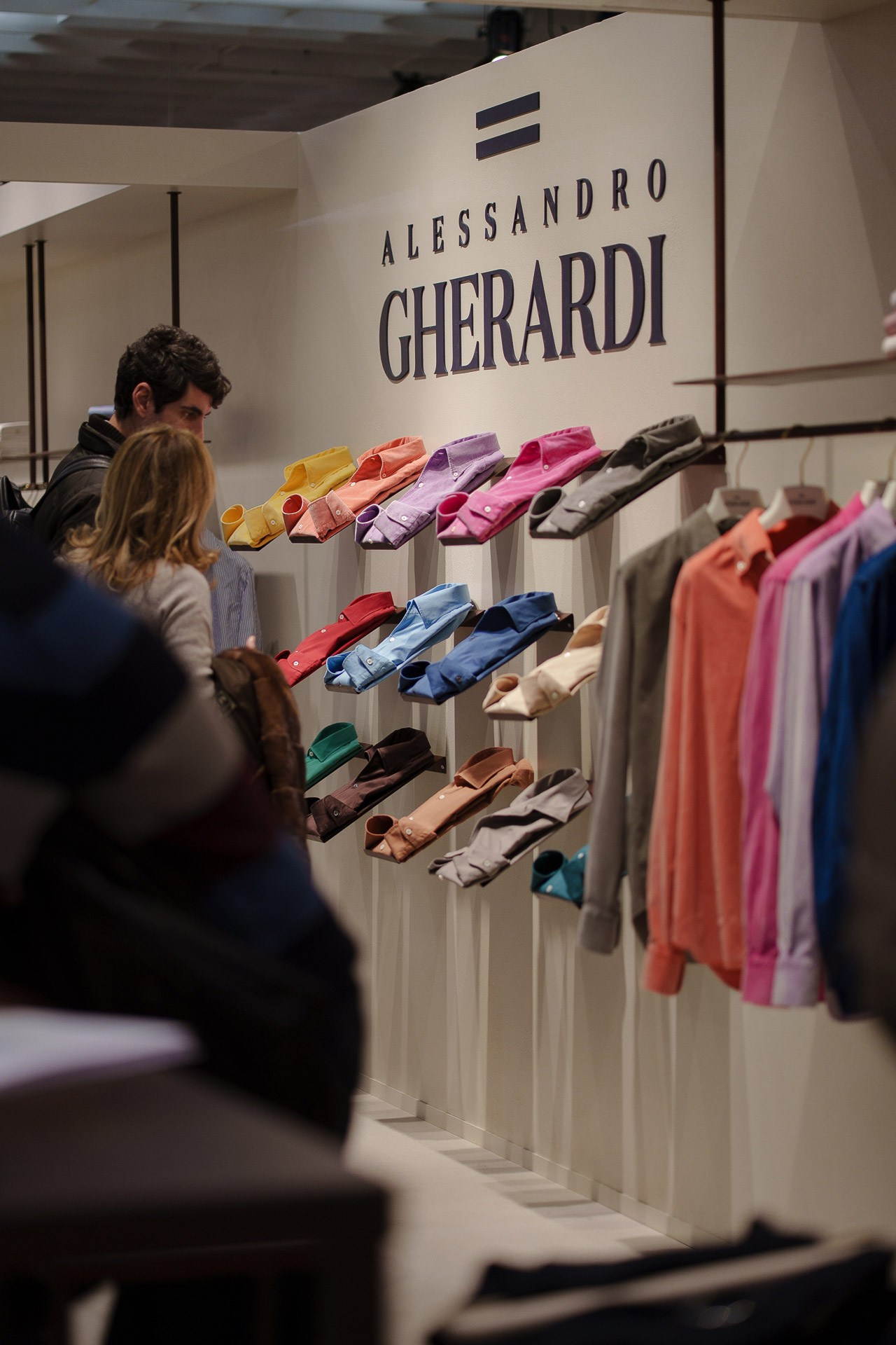 Perspective view of the iconic shirt wall at the Pitti Uomo exhibition, ranging from yellow to teal hues.