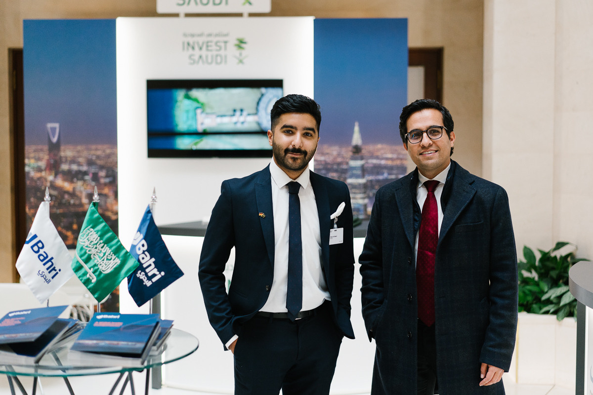 Two business representatives posing at an investment stand during a Saudi-German Commission / conference