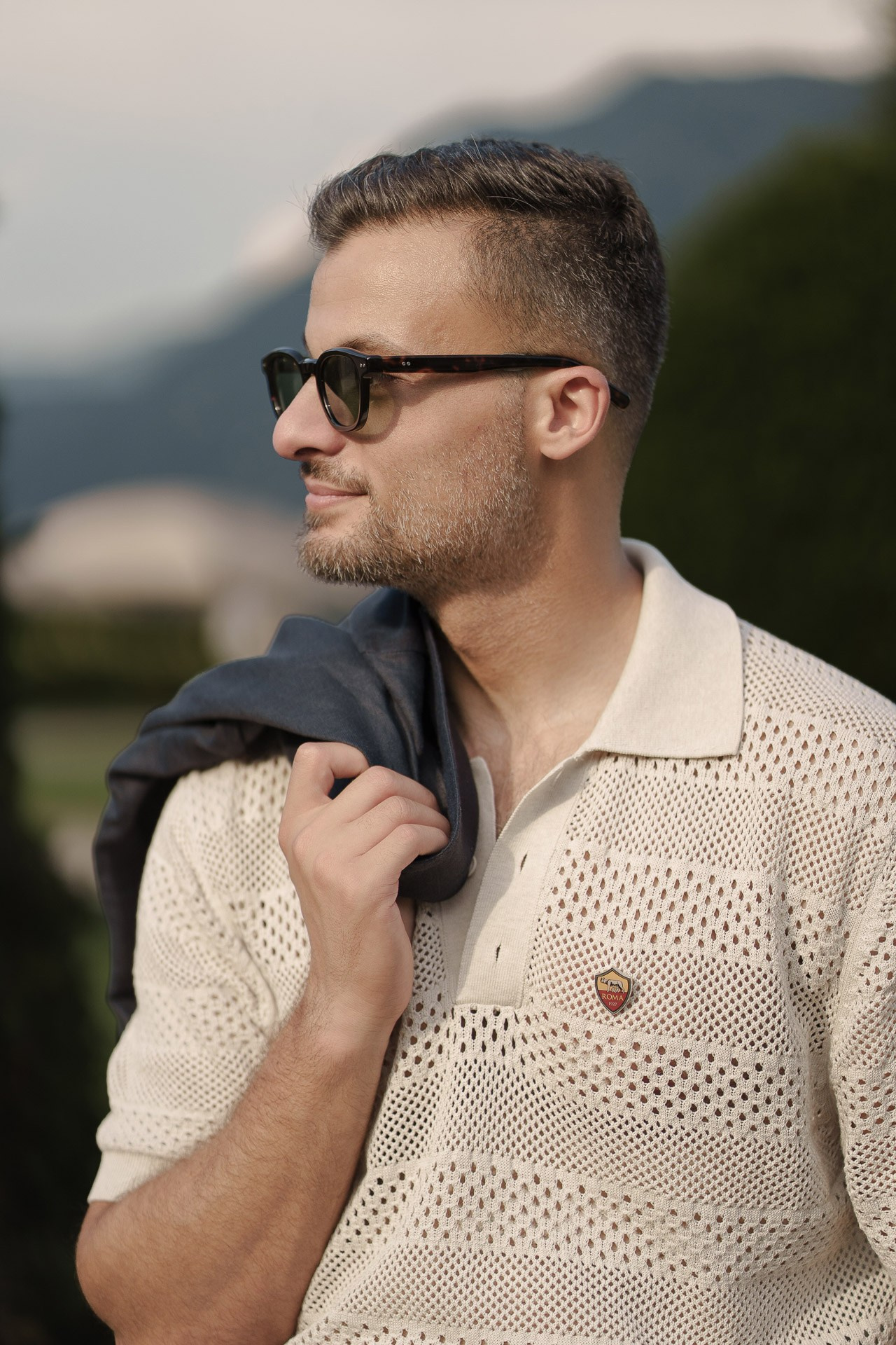 Close-up portrait of Jamal in sunglasses with Lake Como behind him