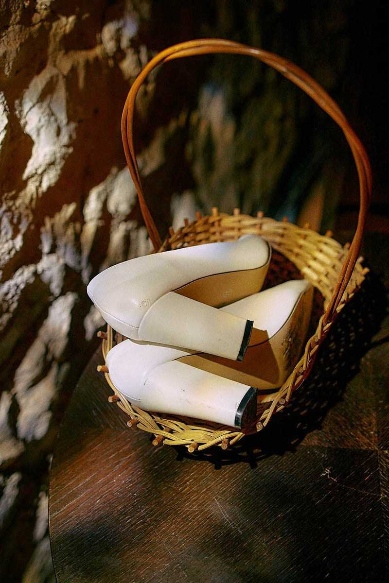 Bride’s discarded shoes in a basket.