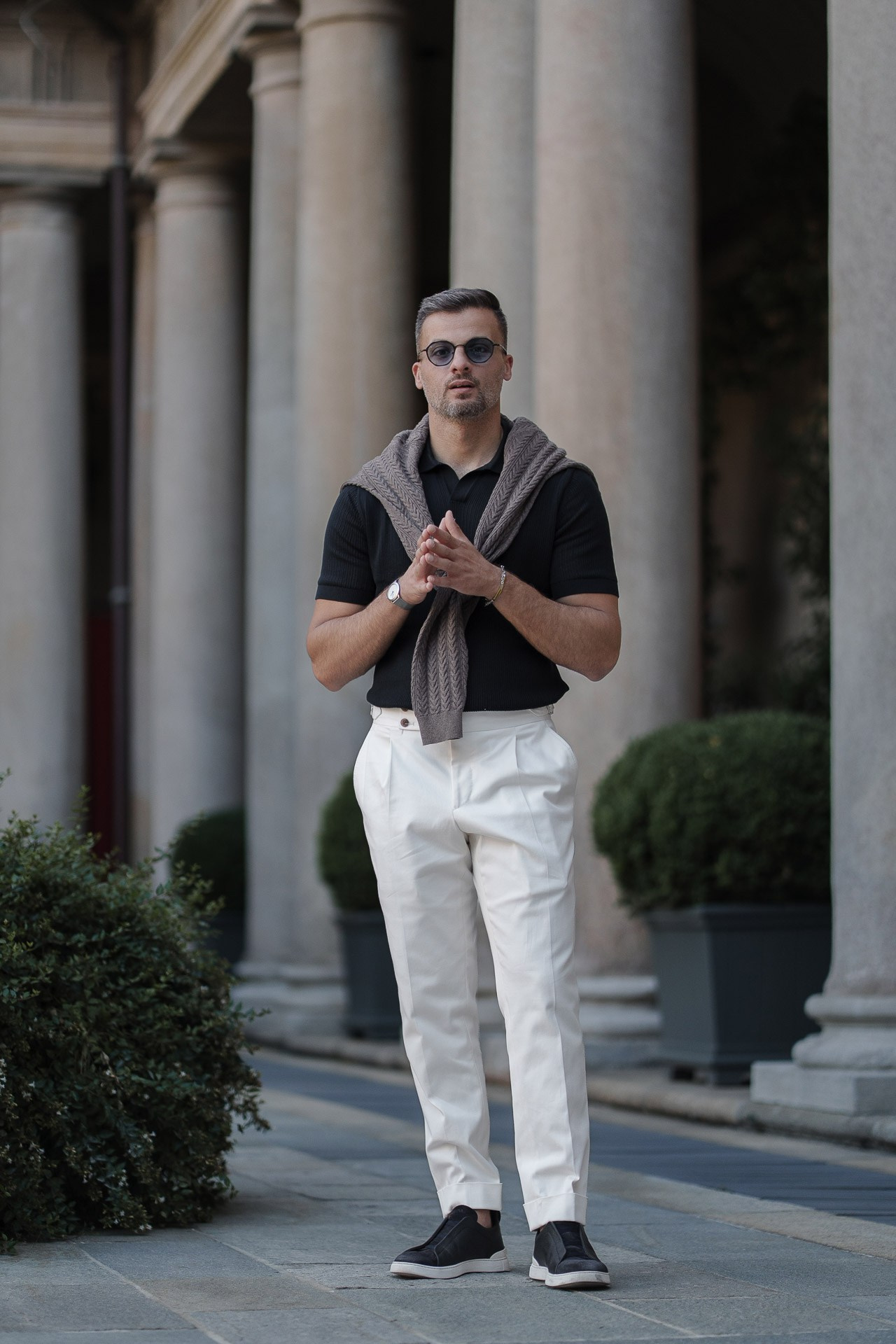 Full-length portrait of Jamal outside an elegant hotel entrance in Milan