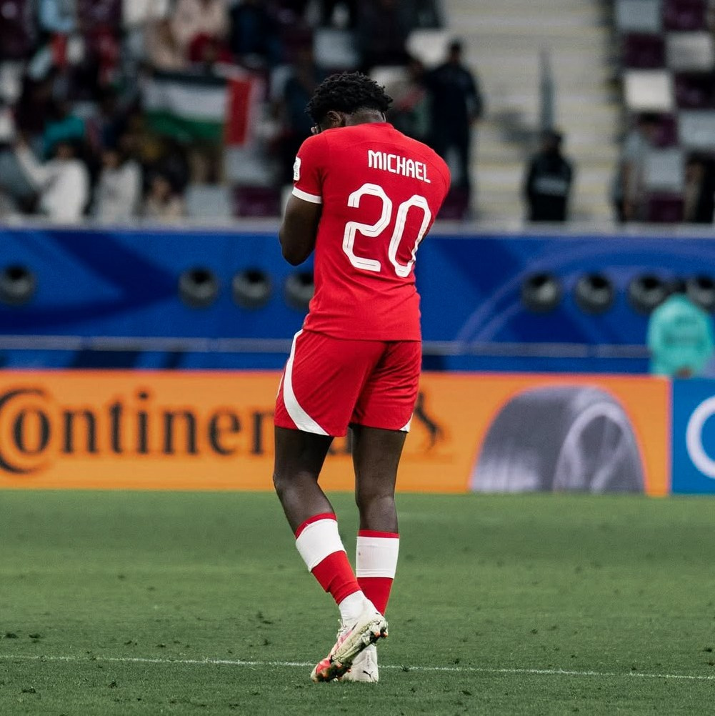 Football player wearing number 20 walking off the pitch after a match, atmospheric football photography.