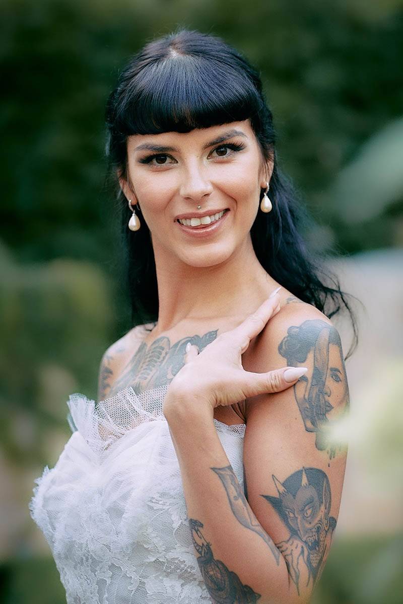 Gothic bride glamorous direct portrait in lush Prague hotel grounds.