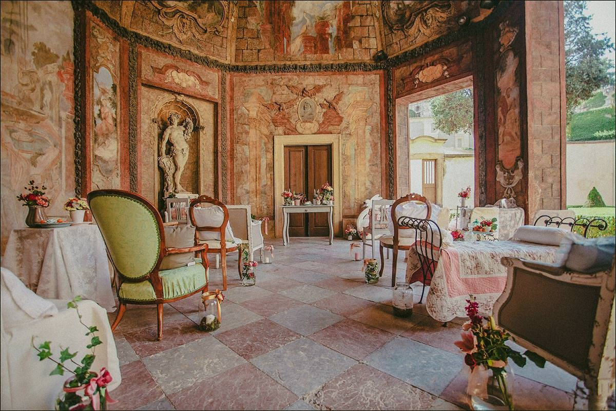 Wide-angle view of the Sala Terrena transformed with flowers and antique furniture for a designer wedding at Vrtba Garden